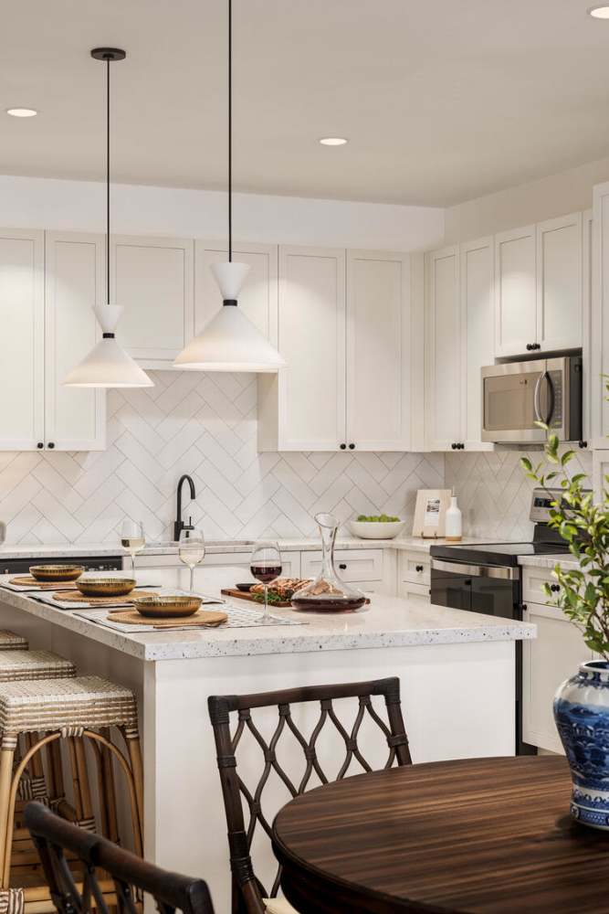 Modern kitchen with island and pendant lights at Romero Apartments in Pensacola, Florida