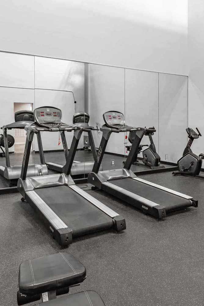 Fitness center with treadmills at Preston Racquet Club Apartments in Dallas, Texas