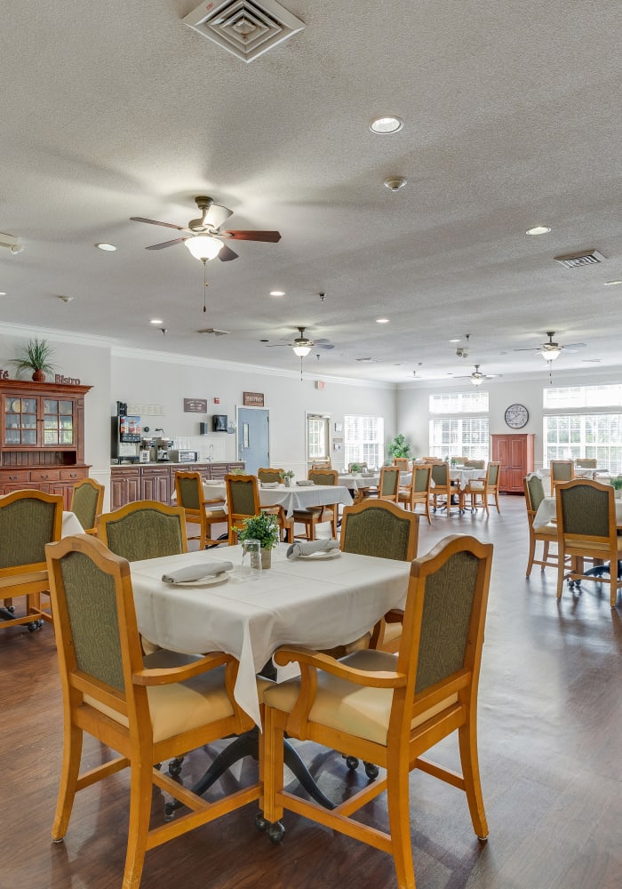 Set dining tables in the dining room at Village Cove Assisted Living in Hilton Head Island, South Carolina