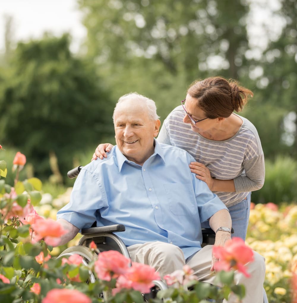 Resident sitting and talking to a caretaker while among flowers at Blossom Springs in Oakland Twp, Michigan