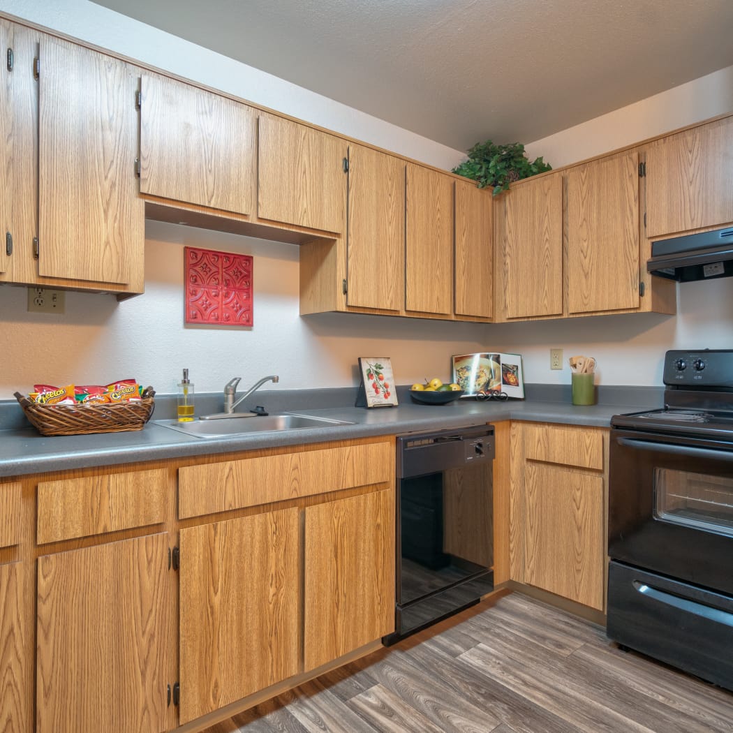 Kitchen with custom countertops overlooking a spacious living room at Argenta Apartment Homes in Mesa, Arizona