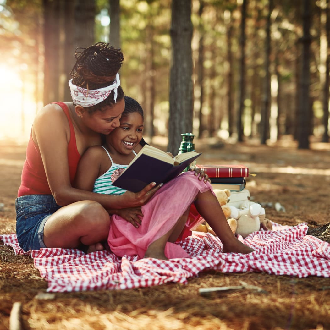 Mother and daughter reading together at a park in Indian Head, Maryland near Charles Landing South