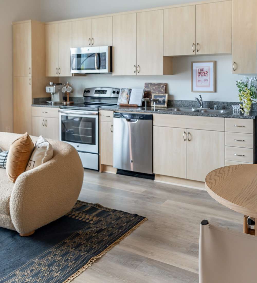 Updated kitchen with stainless steel appliances, including refrigerator and dishwasher at Nova Apartment Homes in San Diego, California