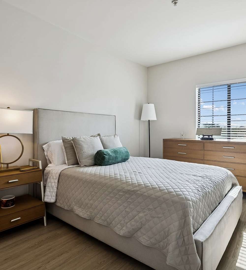 Model bedroom with wood-style flooring at The Linden in Covington, Louisiana