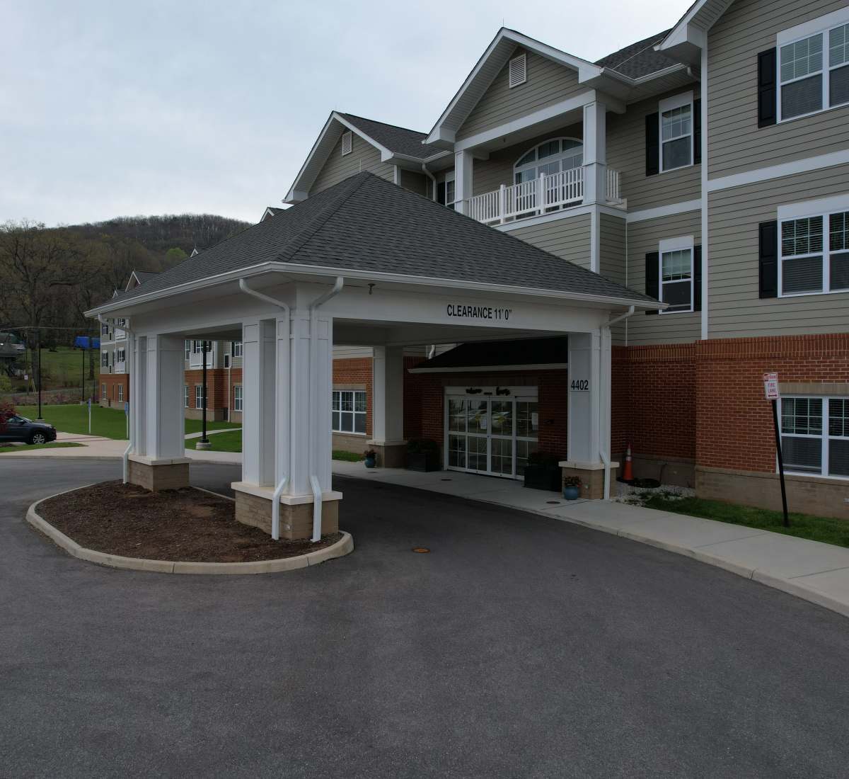 Entrance of the apartment building with shelter at The Harmony Collection at Roanoke - Memory Care in Roanoke, Virginia