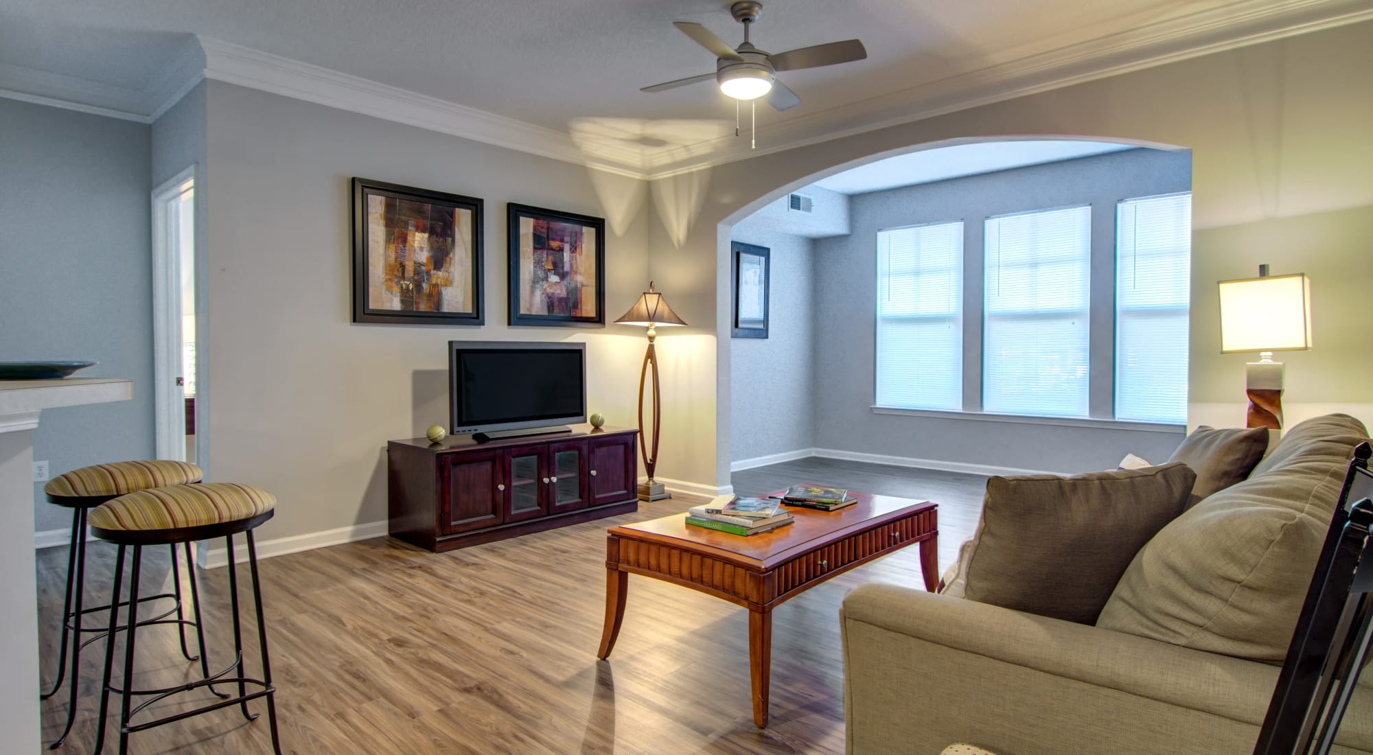 Open-concept layout with hardwood floors and a ceiling fan in a model home at Landing Square in Atlanta, Georgia