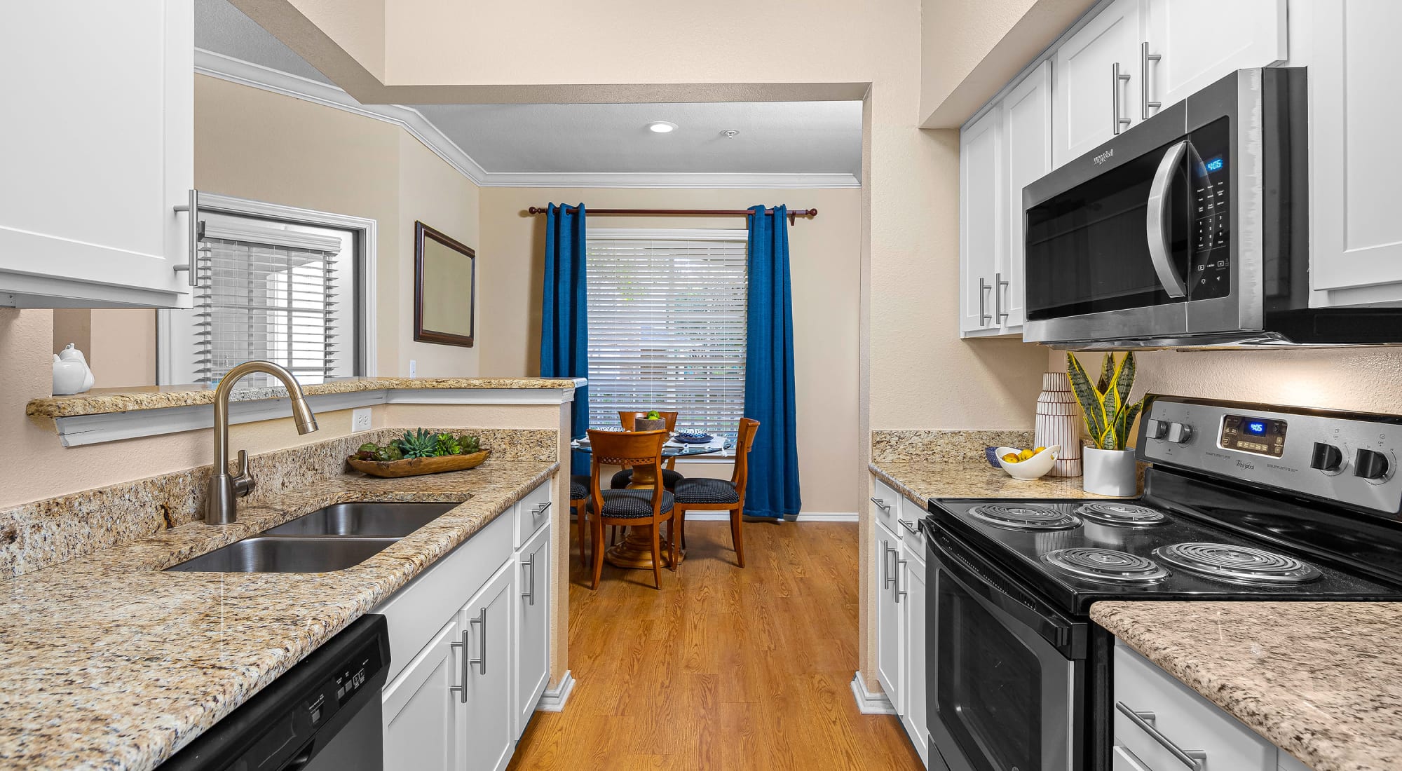 Kitchen with stainless steel appliances and view of dining room at The Lodge at Shavano Park