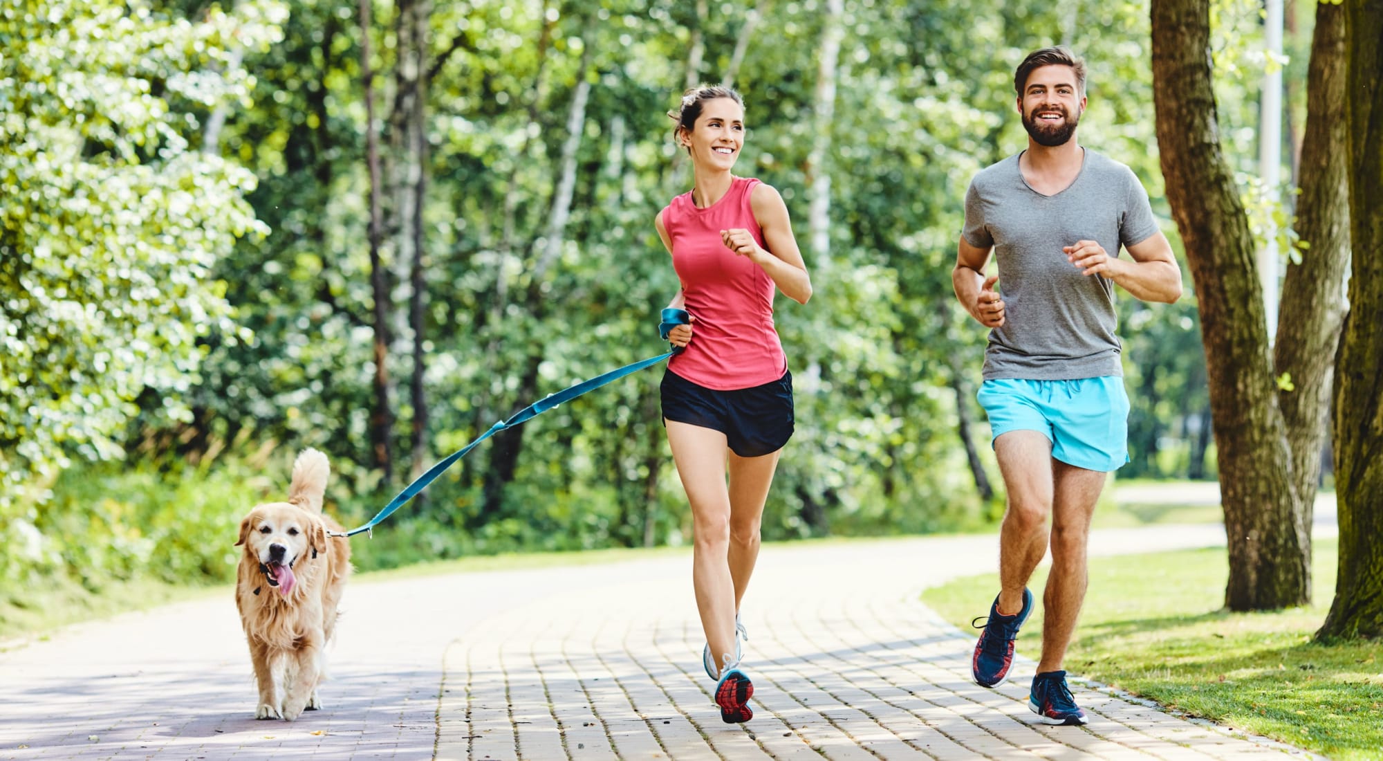 Couple running with their dog in Minneapolis, Minnesota near Loring Park Apartments