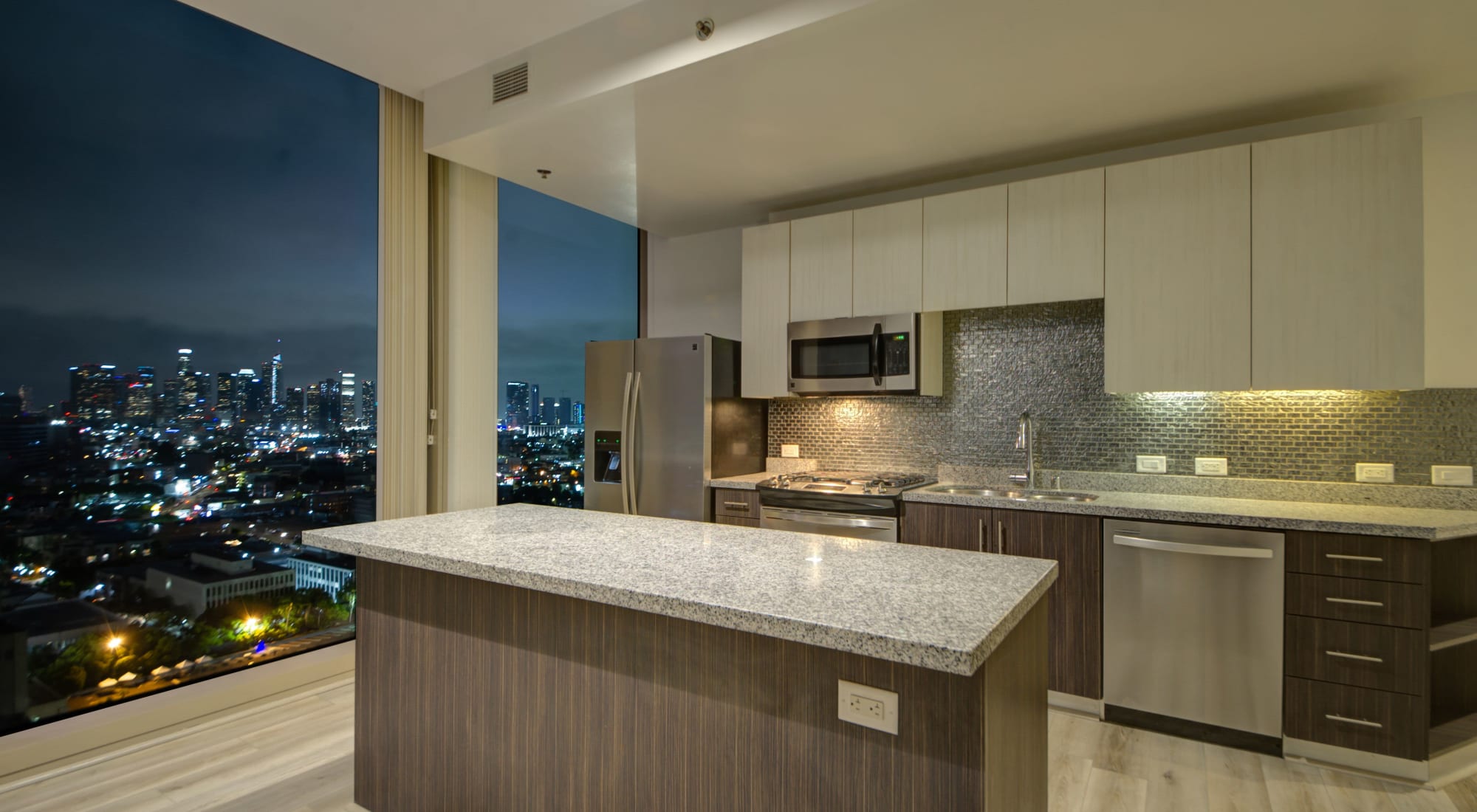 Spacious kitchen with island and view of city at The Vermont in Los Angeles, California