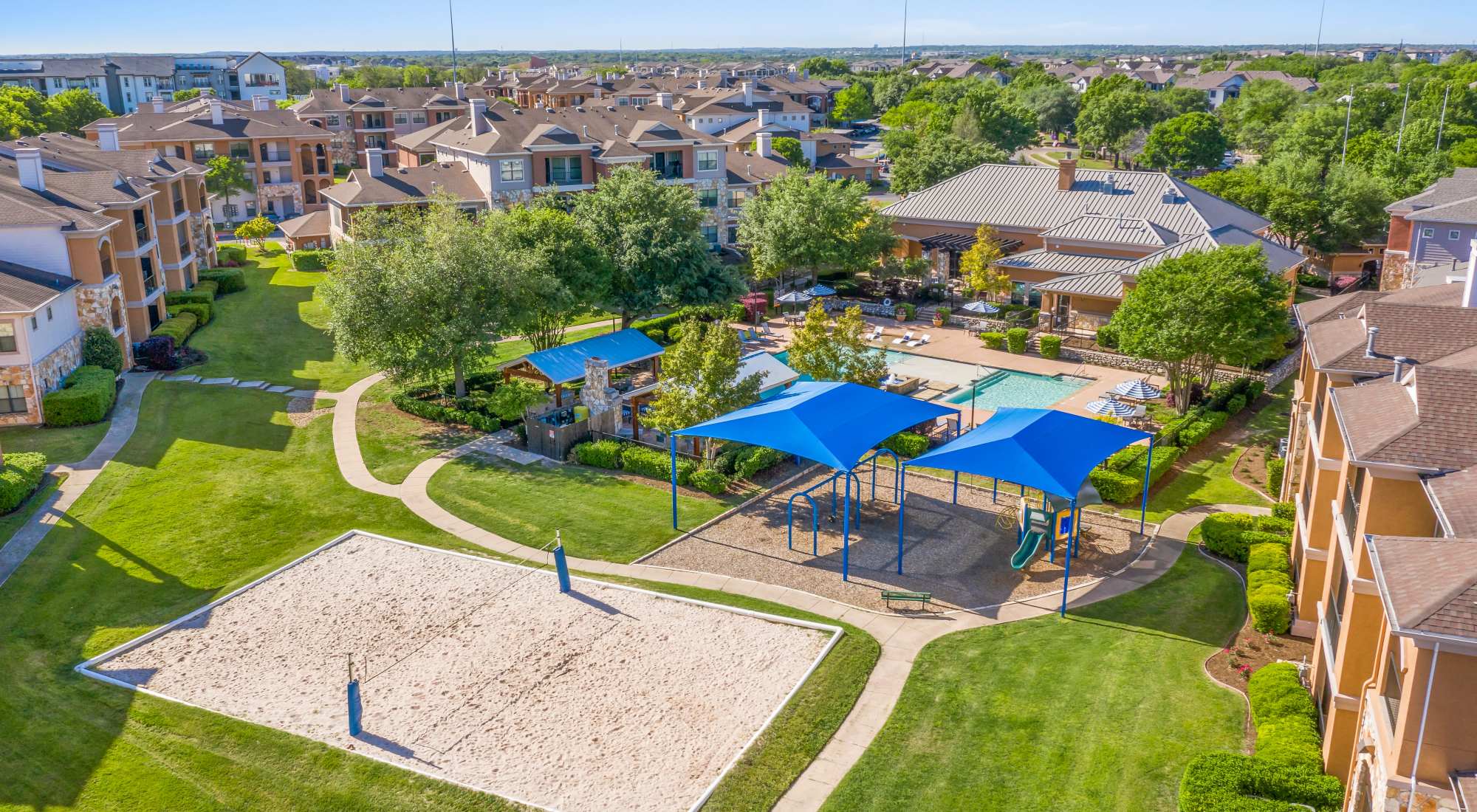 Ariel view of sand volleyball court, playground, and swimming pool at Onion Creek