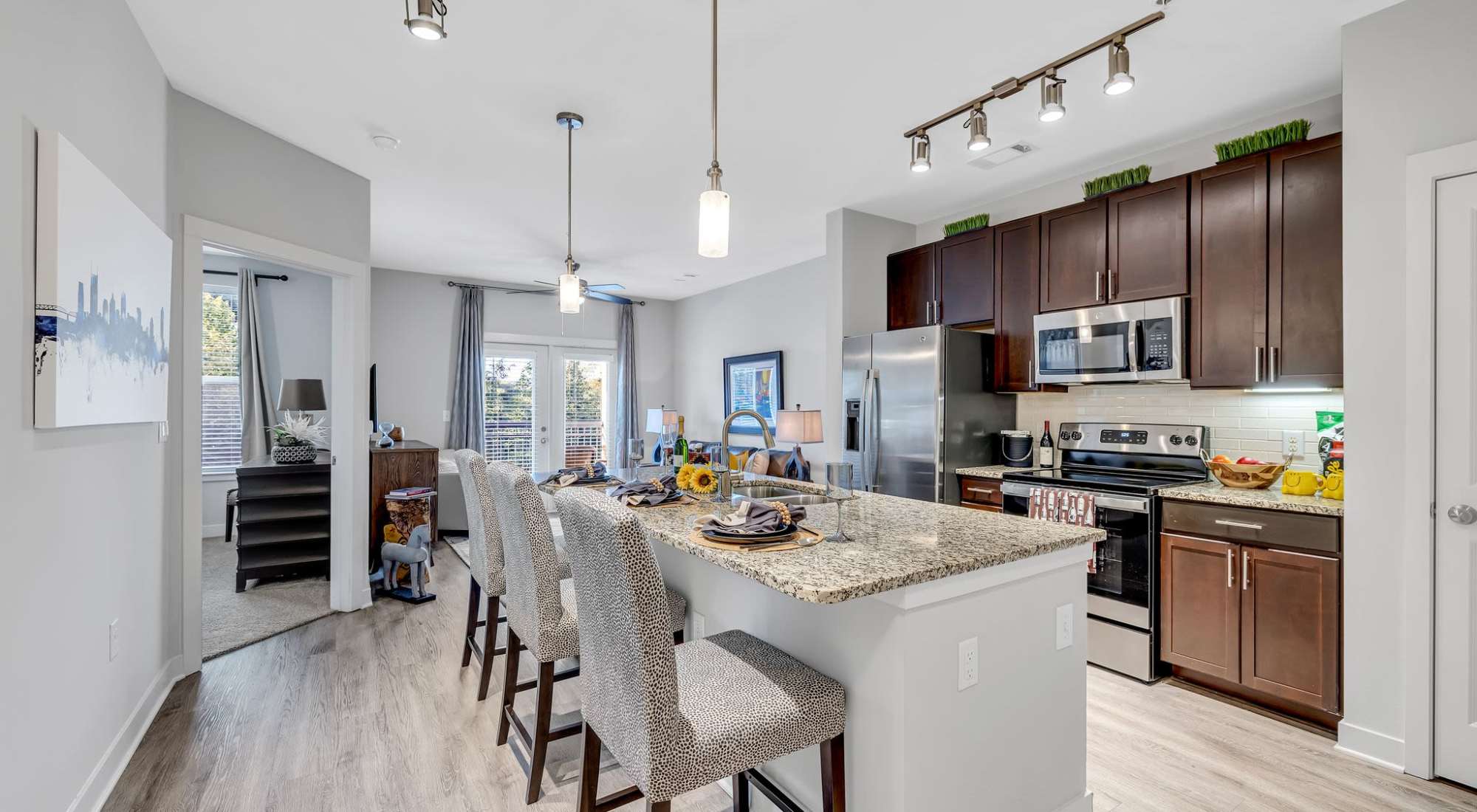 A Kitchen With Stainless Steel Appliances, Granite Countertops, And Seating For Four. at Artessa in Franklin, Tennessee