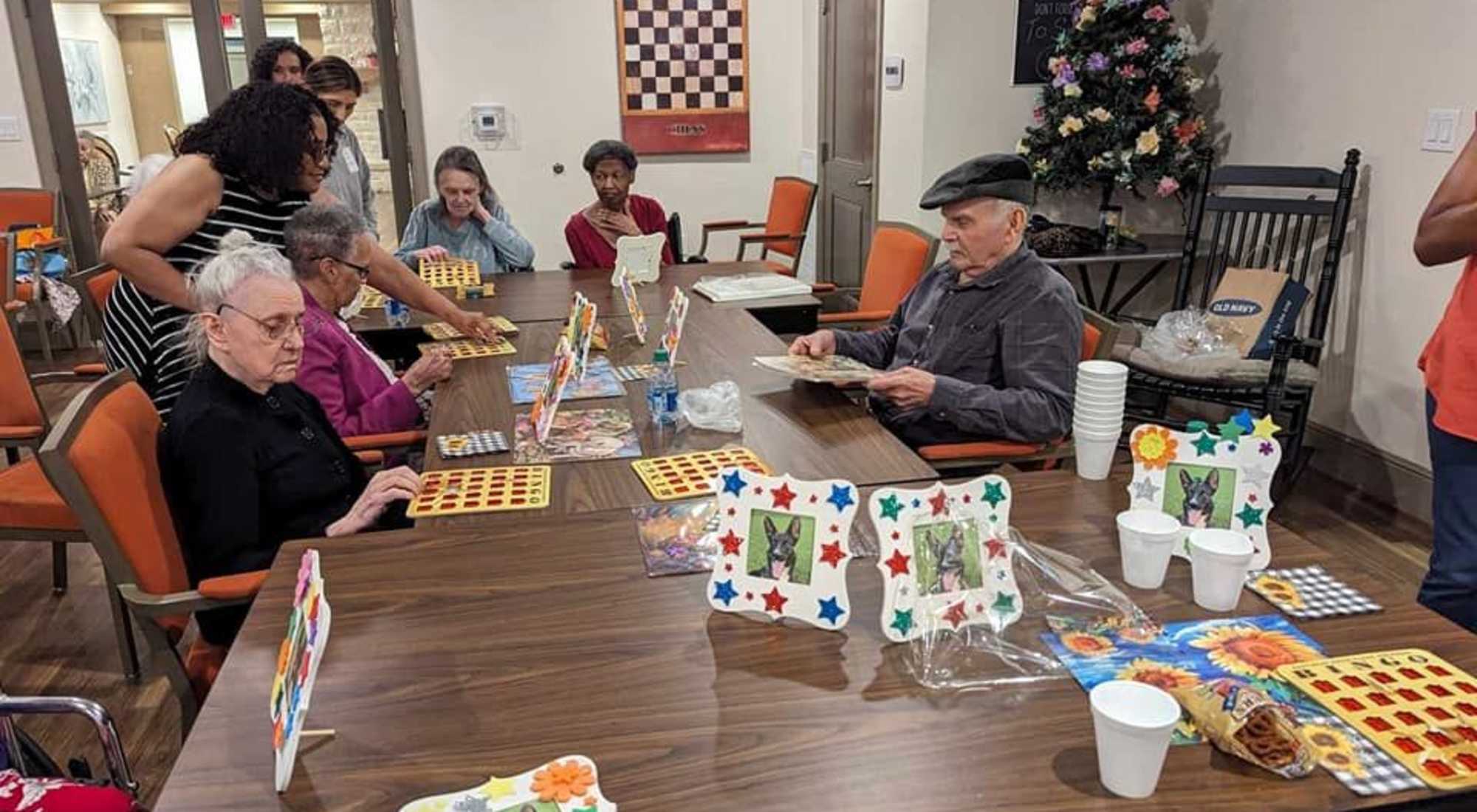Seniors having fun playing BINGO together while eating snacks.