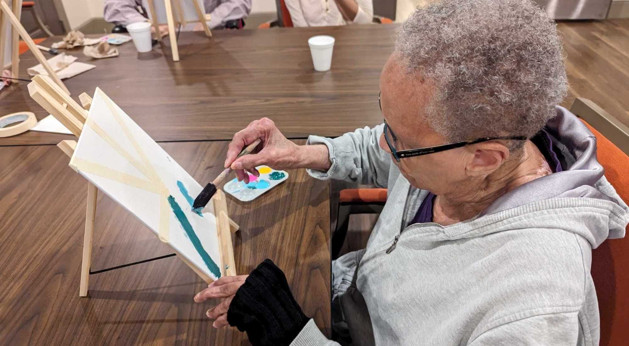 Elderly women being reactive and enjoying the crafts at the landing while painting.