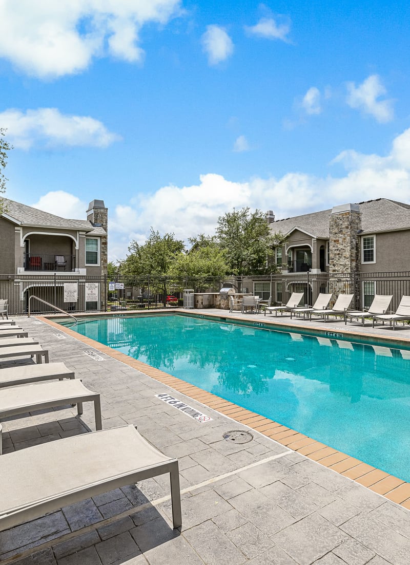 Lighted pool at sunset overlooking units at Marquis at The Cascades in Tyler, Texas