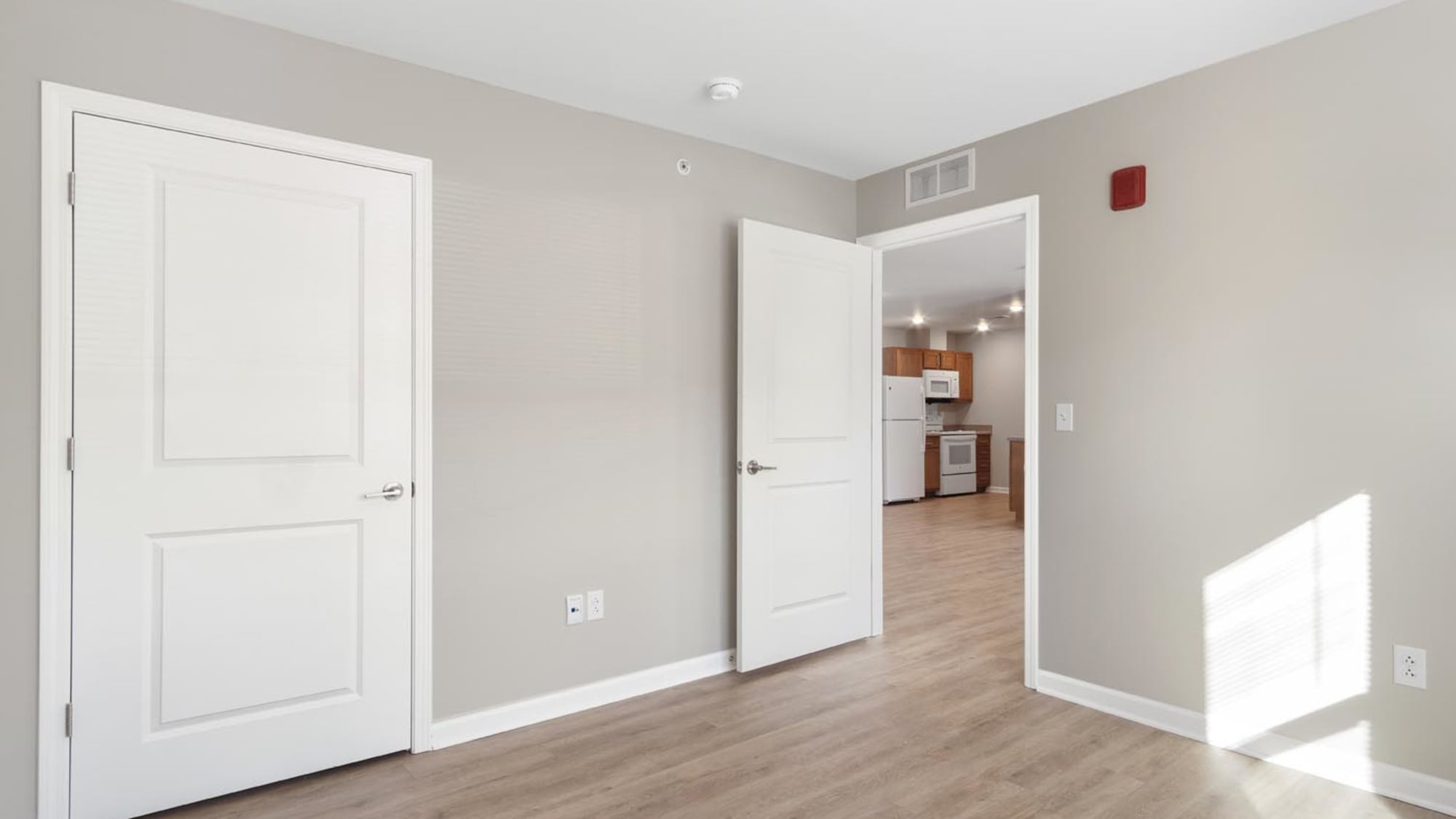 Bedroom with a peek of living area and kitchen at Trolley Circle in Belleville, Illinois