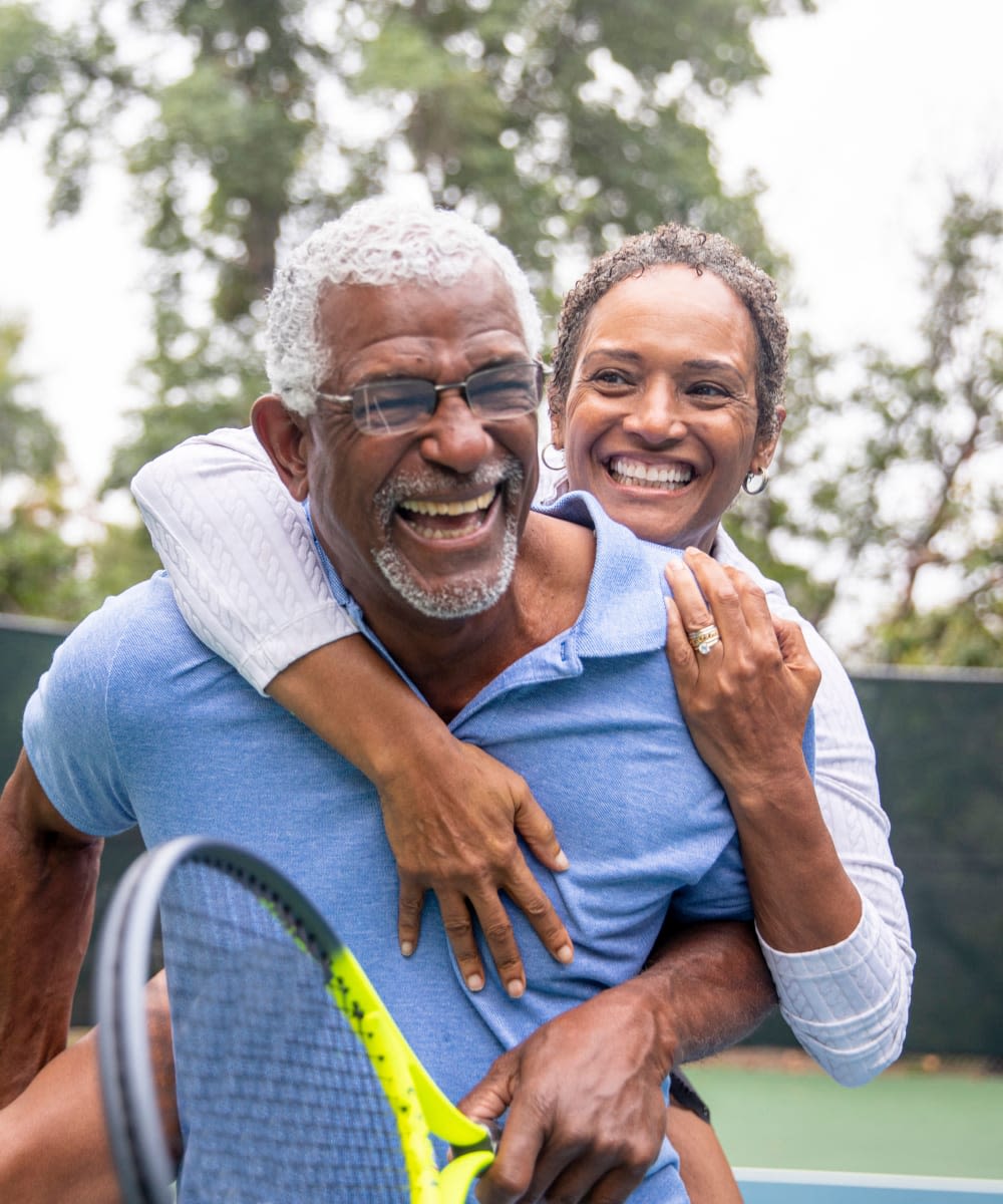 Resident couple playing tennis at Village on the Park Friendswood in Friendswood, Texas