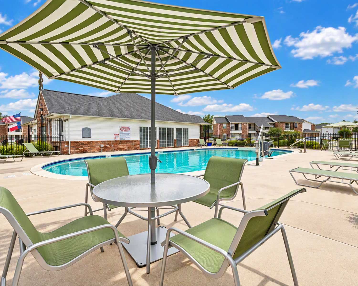 Swimming pool with lounge chairs and umbrellas at Meadowbrook Plaza in Houston, Texas