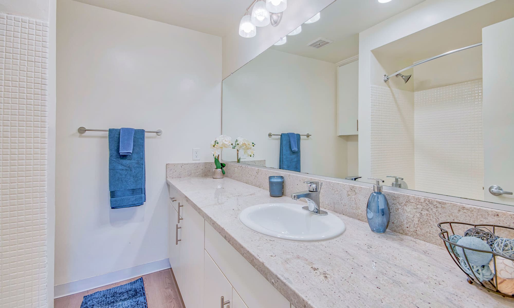 Ample countertop space and a large vanity mirror in a model home's bathroom at Villa Vicente in Los Angeles, California