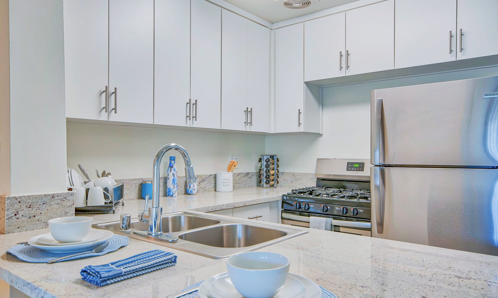 Spacious one bedroom home's kitchen with granite countertops and stainless-steel appliances at Villa Vicente in Los Angeles, California