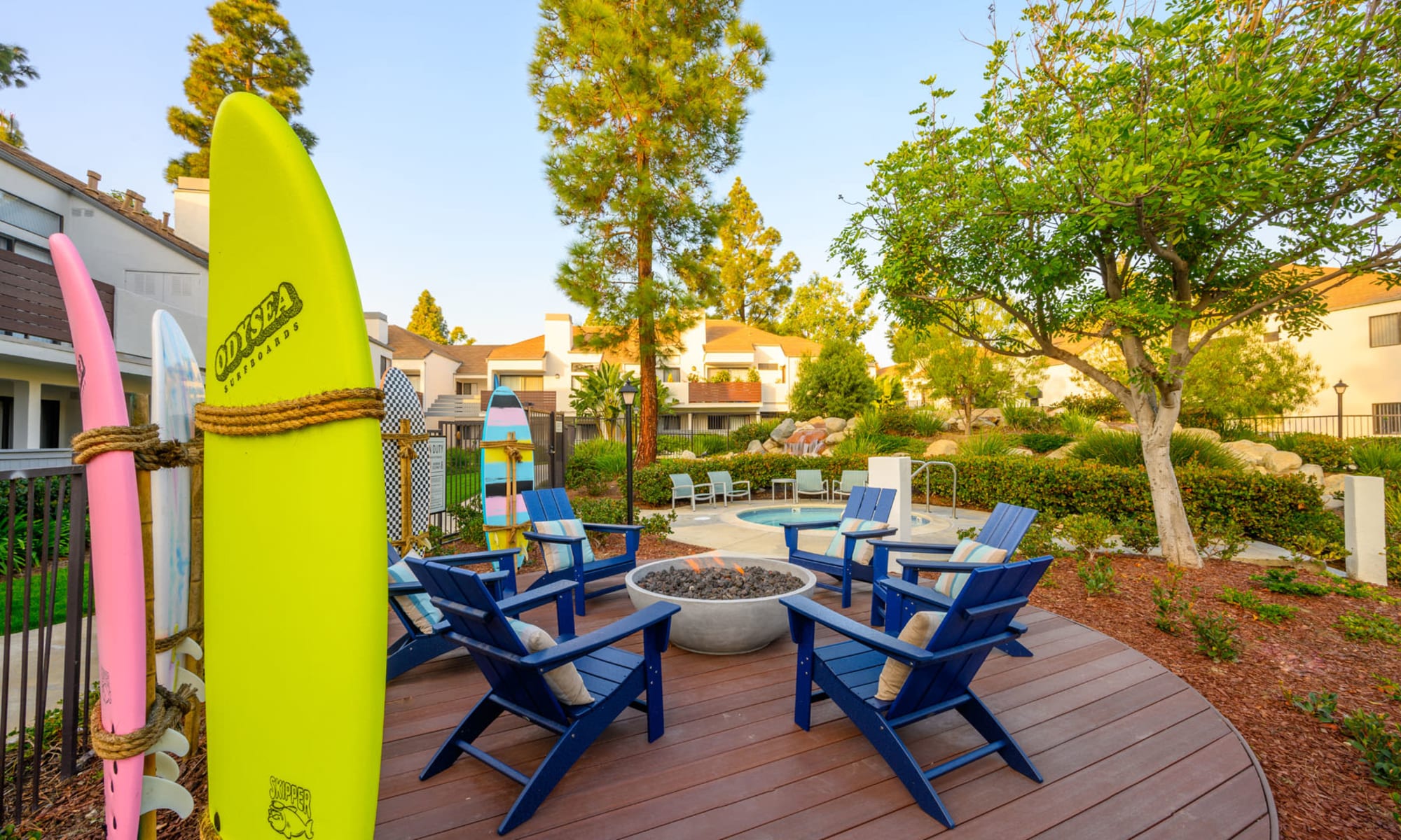 Surfboards and Adirondack chairs around the fire pit at Pleasanton Place Apartment Homes in Pleasanton, California