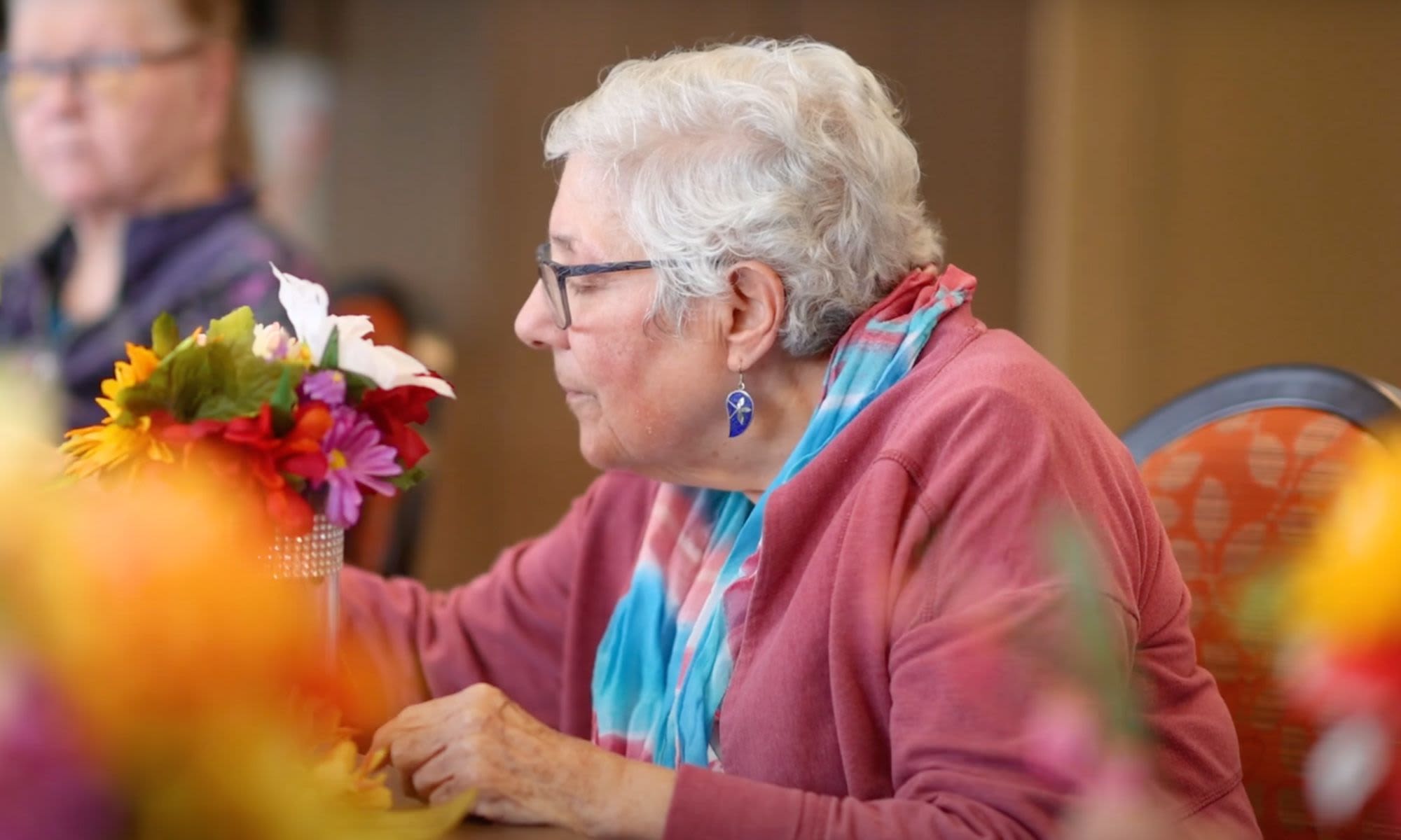 A Resident arranging flowers at Carefield Pleasanton in Pleasanton, California