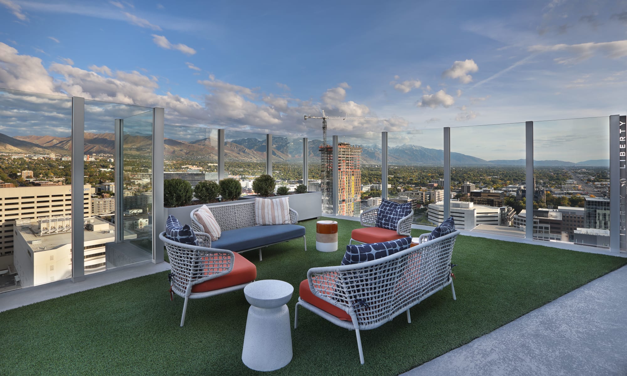 Rooftop patio with white furniture and red and blue cushions and mountain view at Luxury high-rise community of Liberty SKY in Salt Lake City, Utah