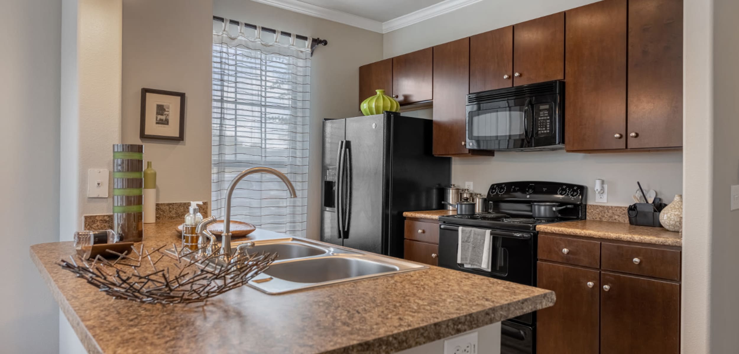 Kitchen with modern appliances and granite counters at Marquis at Sugar Land in Sugar Land, Texas