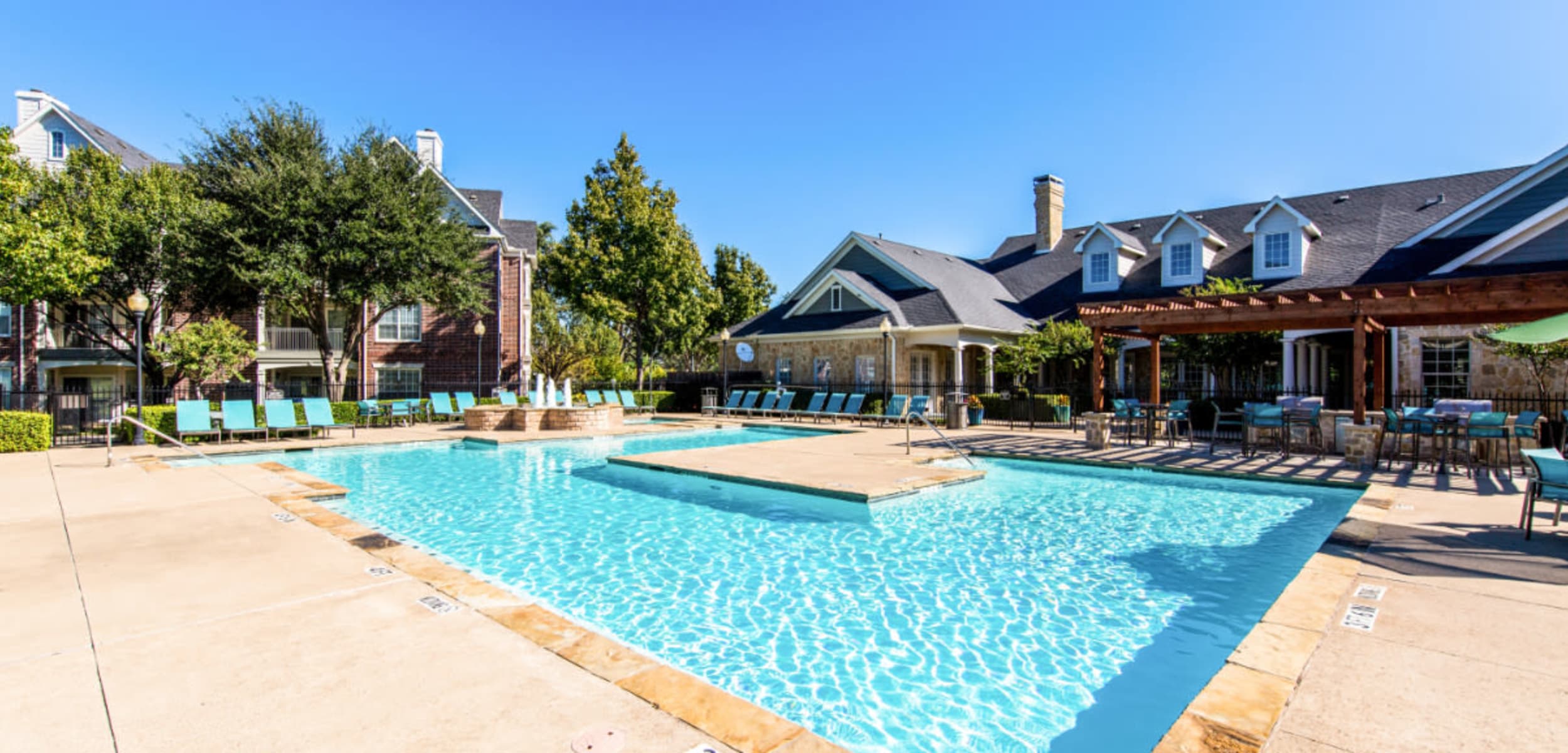 Sparkling pool surrounded by lounge chairs and gazebo area at Marquis at Silver Oaks in Grapevine, Texas