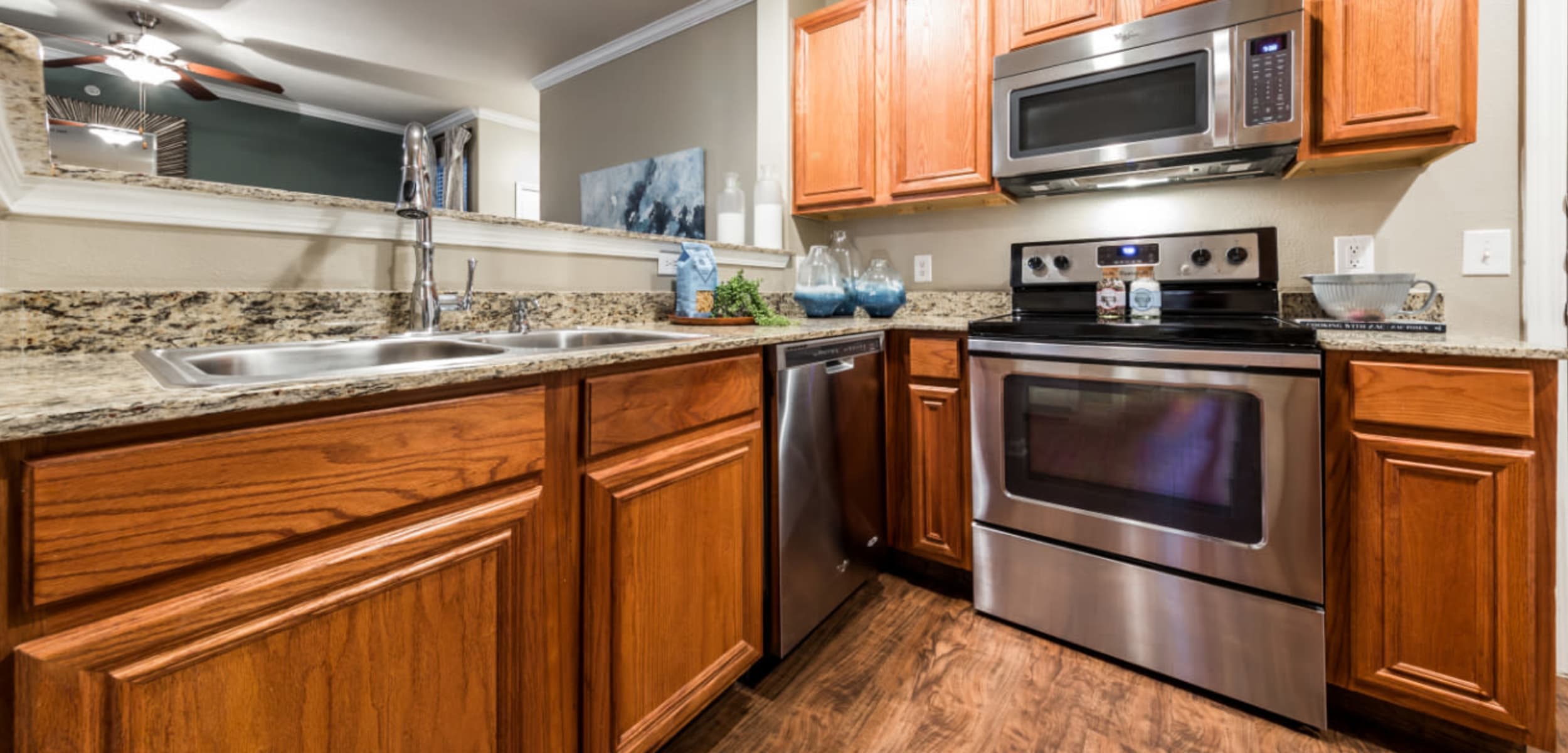 Modern style kitchen with stainless steel appliances and granite countertops at Marquis at The Cascades in Tyler, Texas