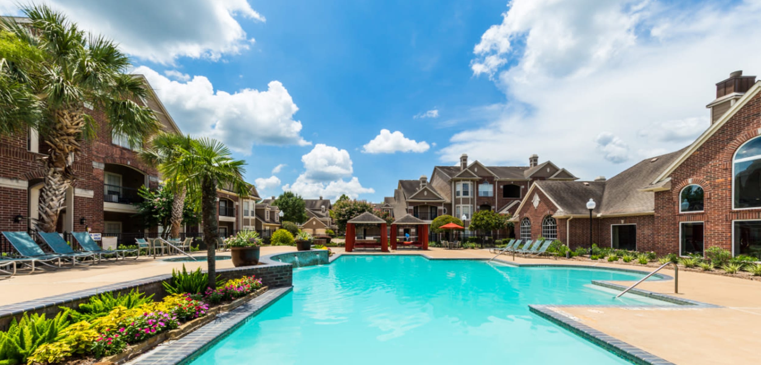 Sparkling pool with water features overlooking gazebos at Marquis on Park Row in Houston Texas,
