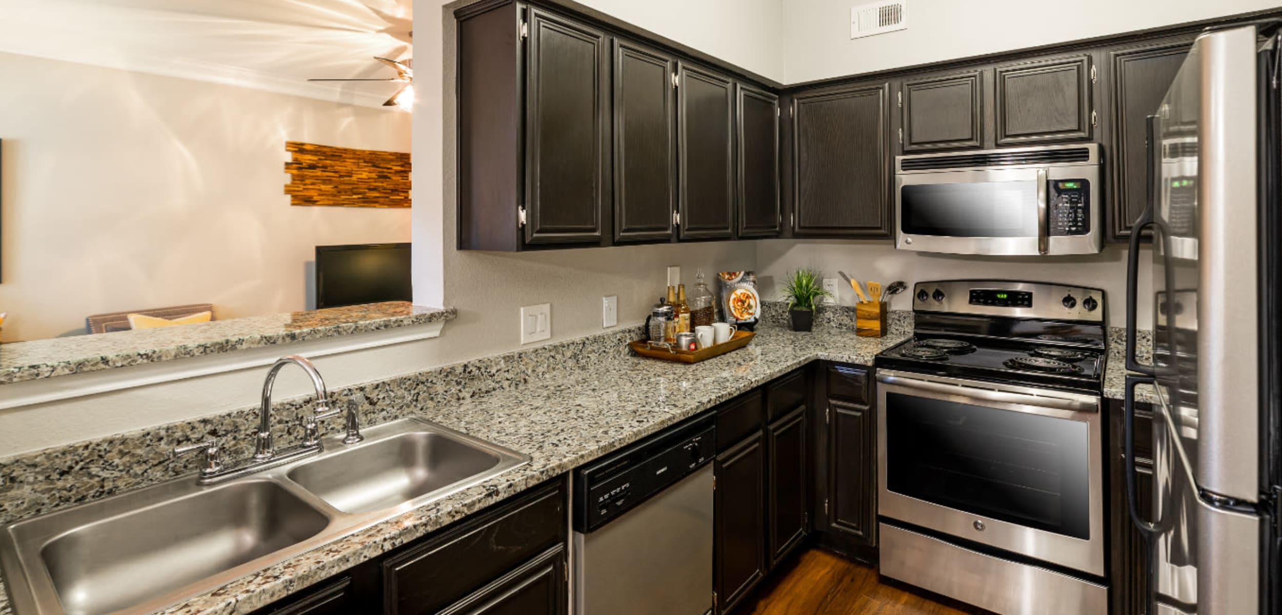 Modern kitchen with stainless steel appliances and granite countertops at Marquis at Great Hills in Austin, Texas