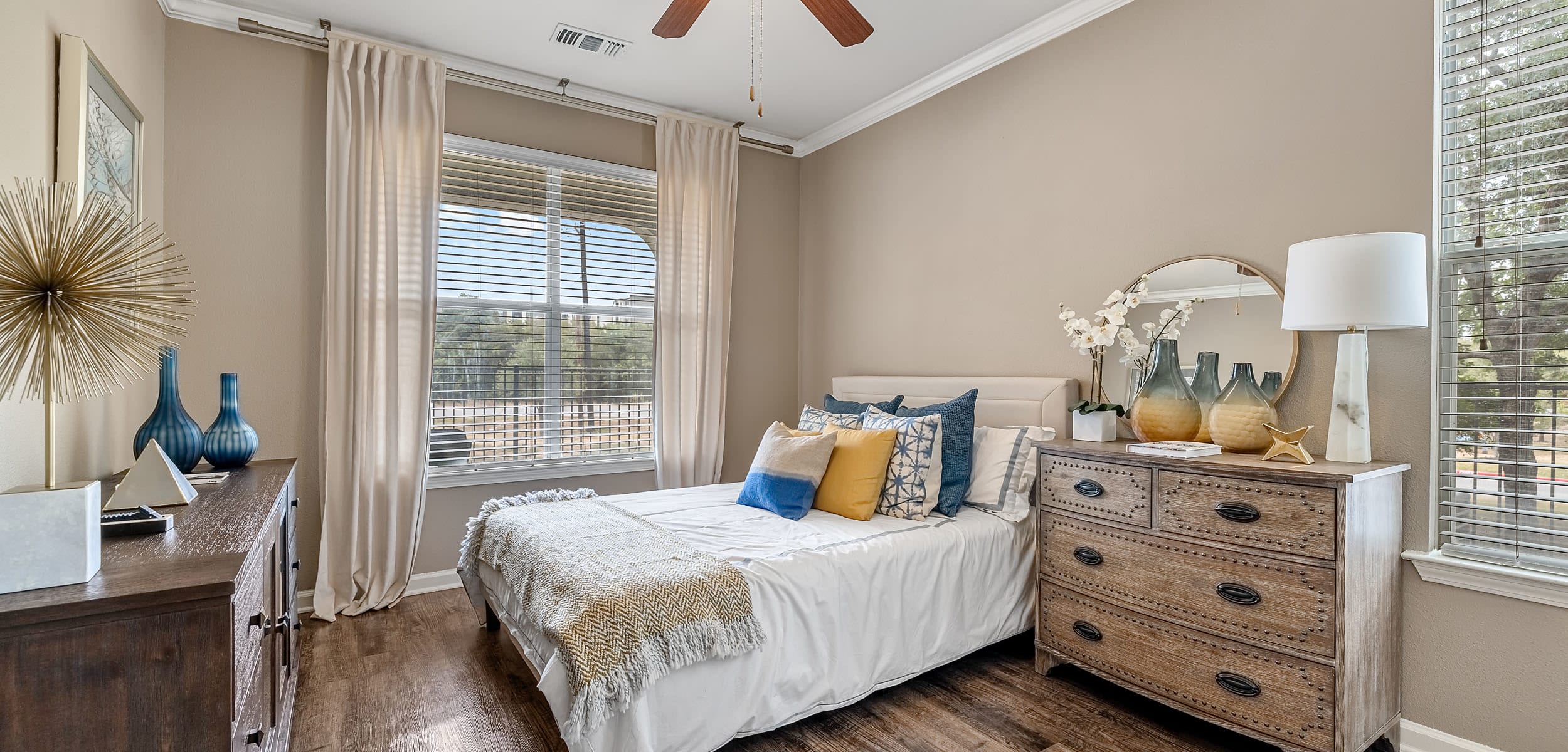 Bedroom with wood floors and a large window at Marquis at Crown Ridge in San Antonio, Texas