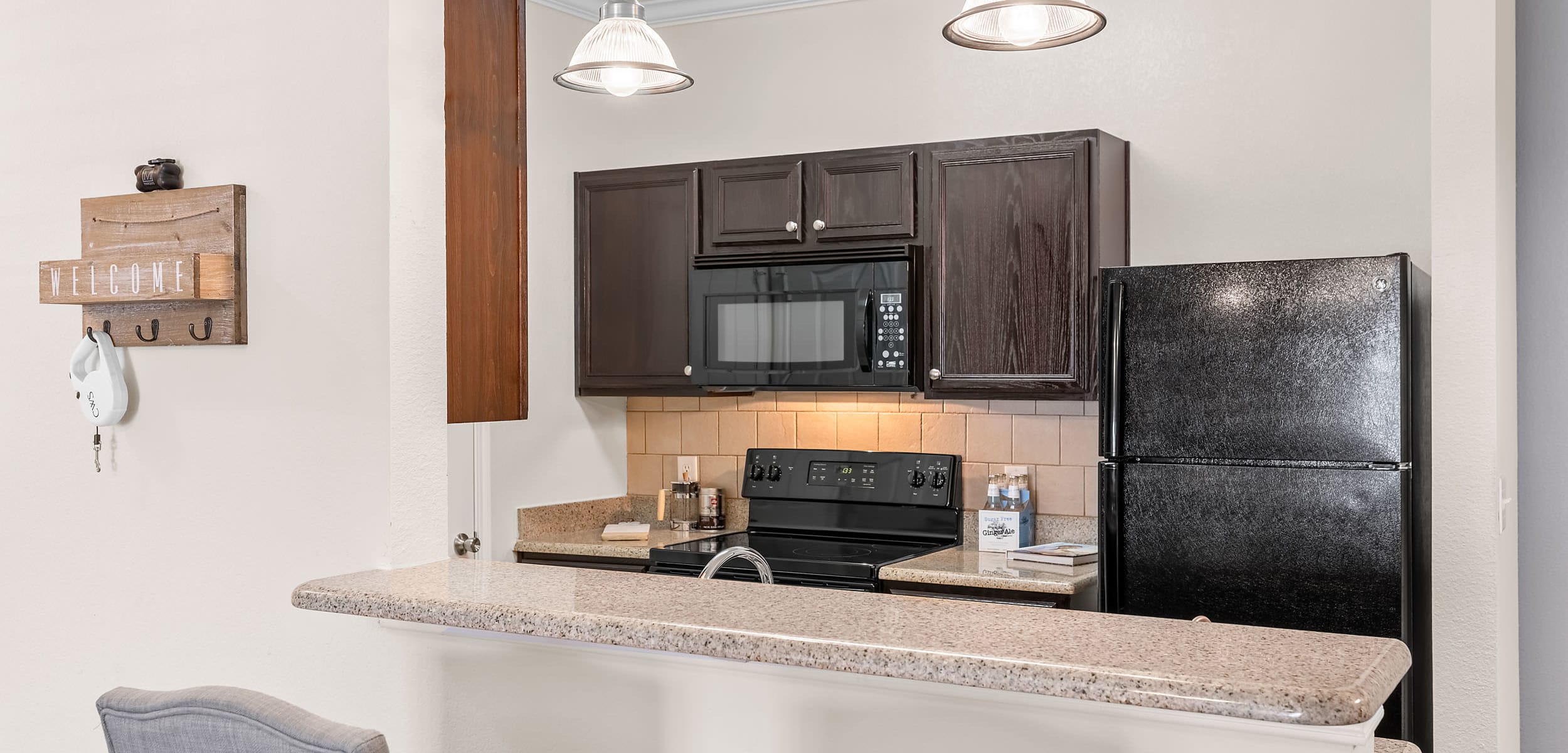 Modern kitchen with black appliances at Marquis at The RIM in San Antonio, Texas