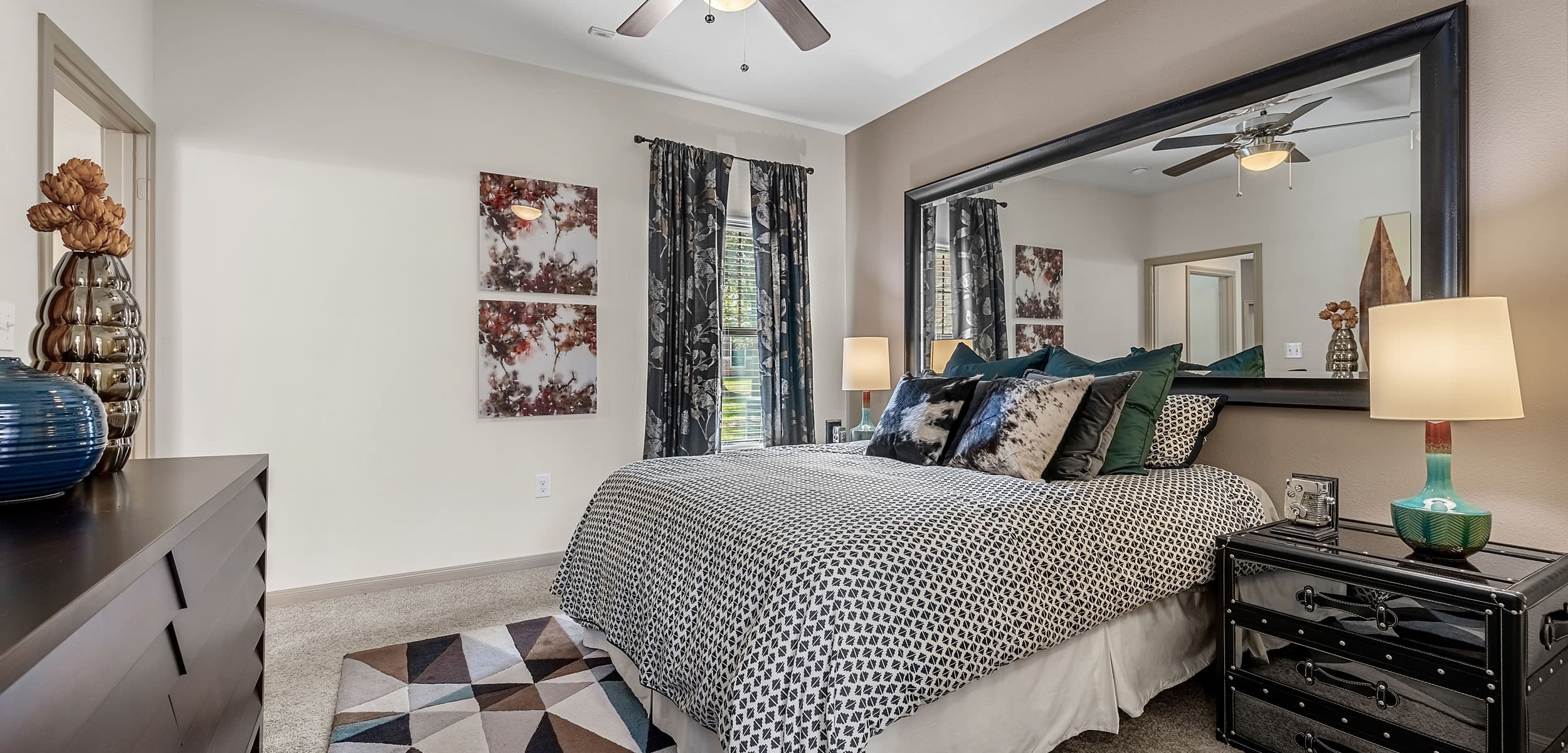 Bright bedroom with a large mirror behind the bed at Marquis on Lakeline in Cedar Park, Texas