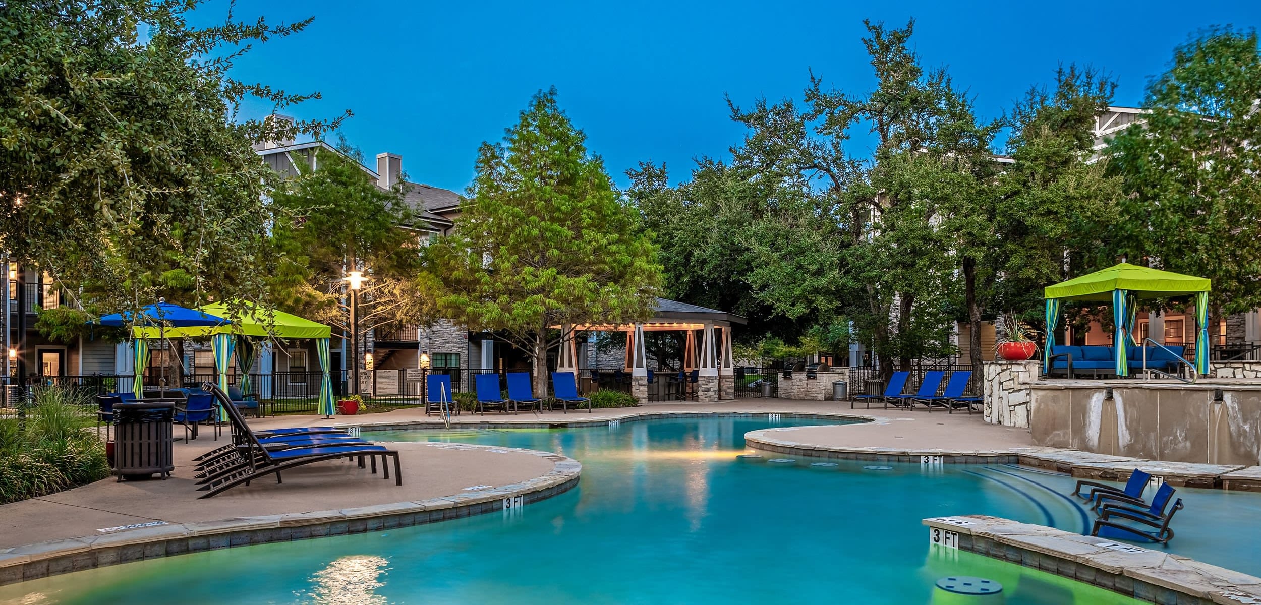 Lit pool with a water feature at Marquis on Lakeline in Cedar Park, Texas