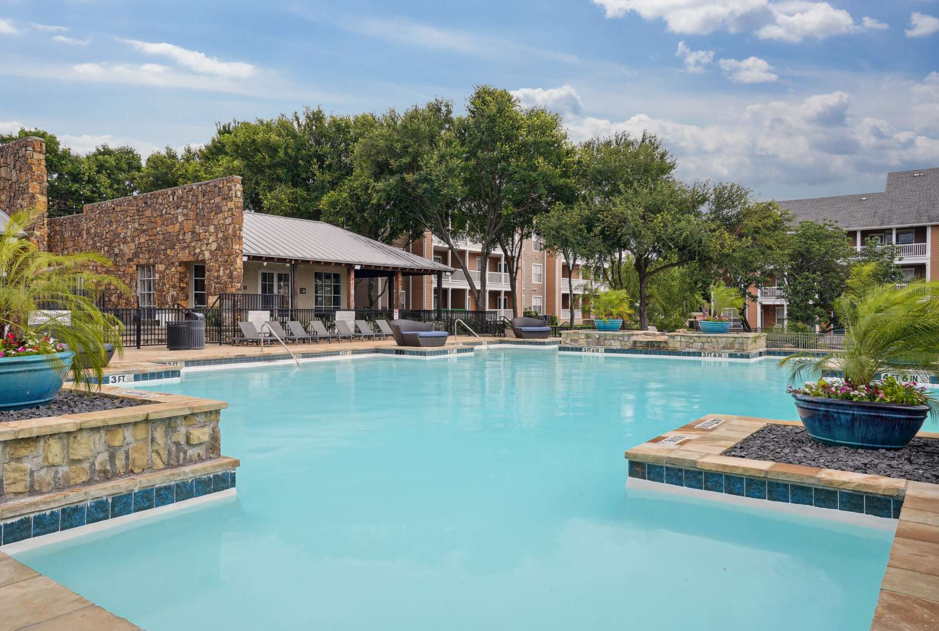 Luxurious swimming pool with lush greenery at Flatiron District at Austin Ranch, The Colony, Texas