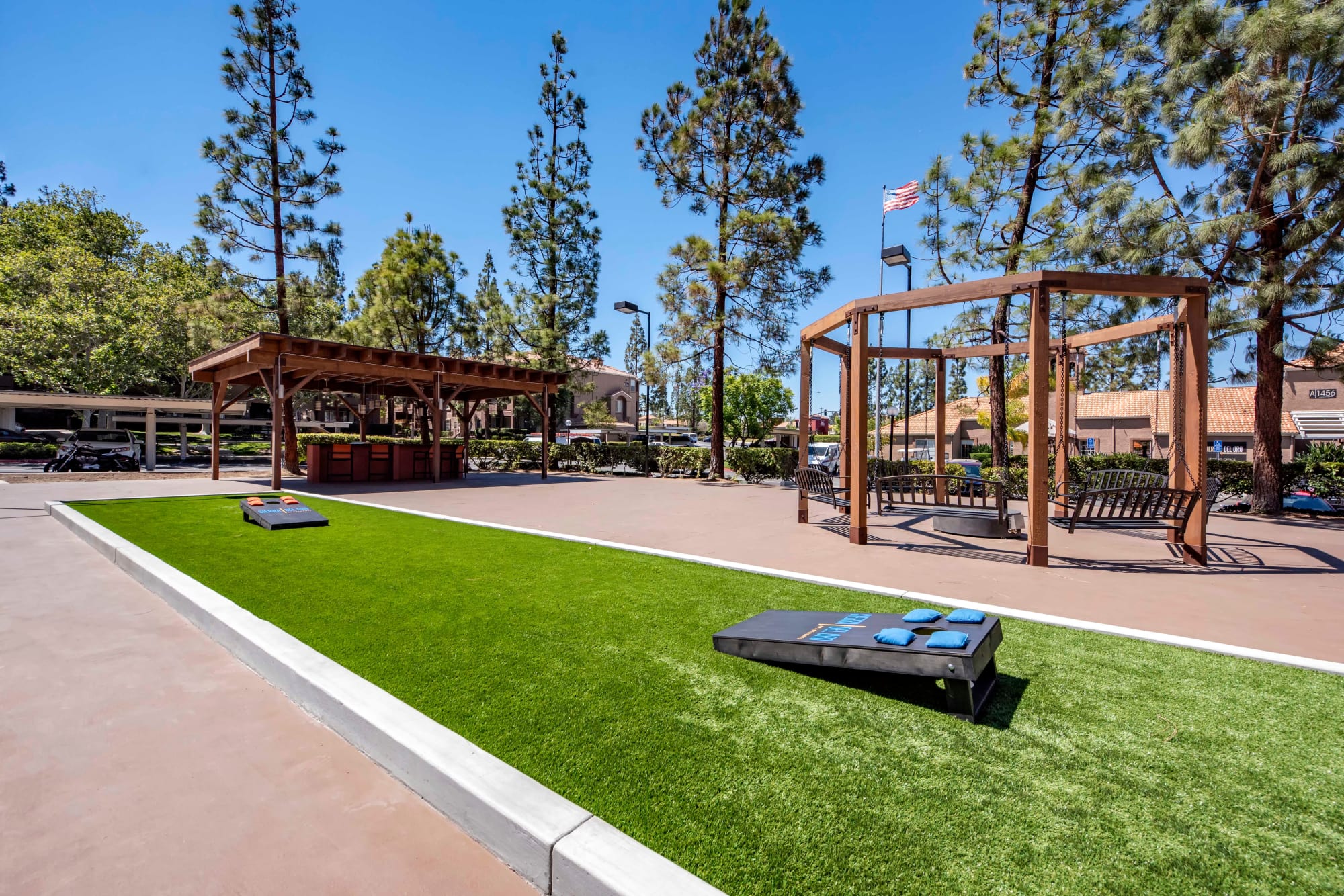 Courtyard with corn hole at Sierra Del Oro Apartments in Corona, California