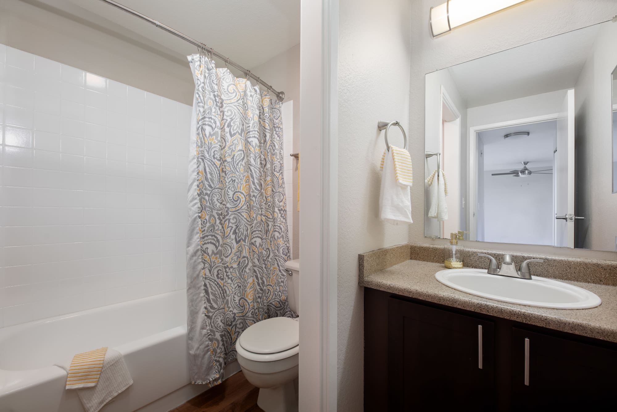 Brown renovated bathroom with a tub at Latitude Apartments in Everett, Washington