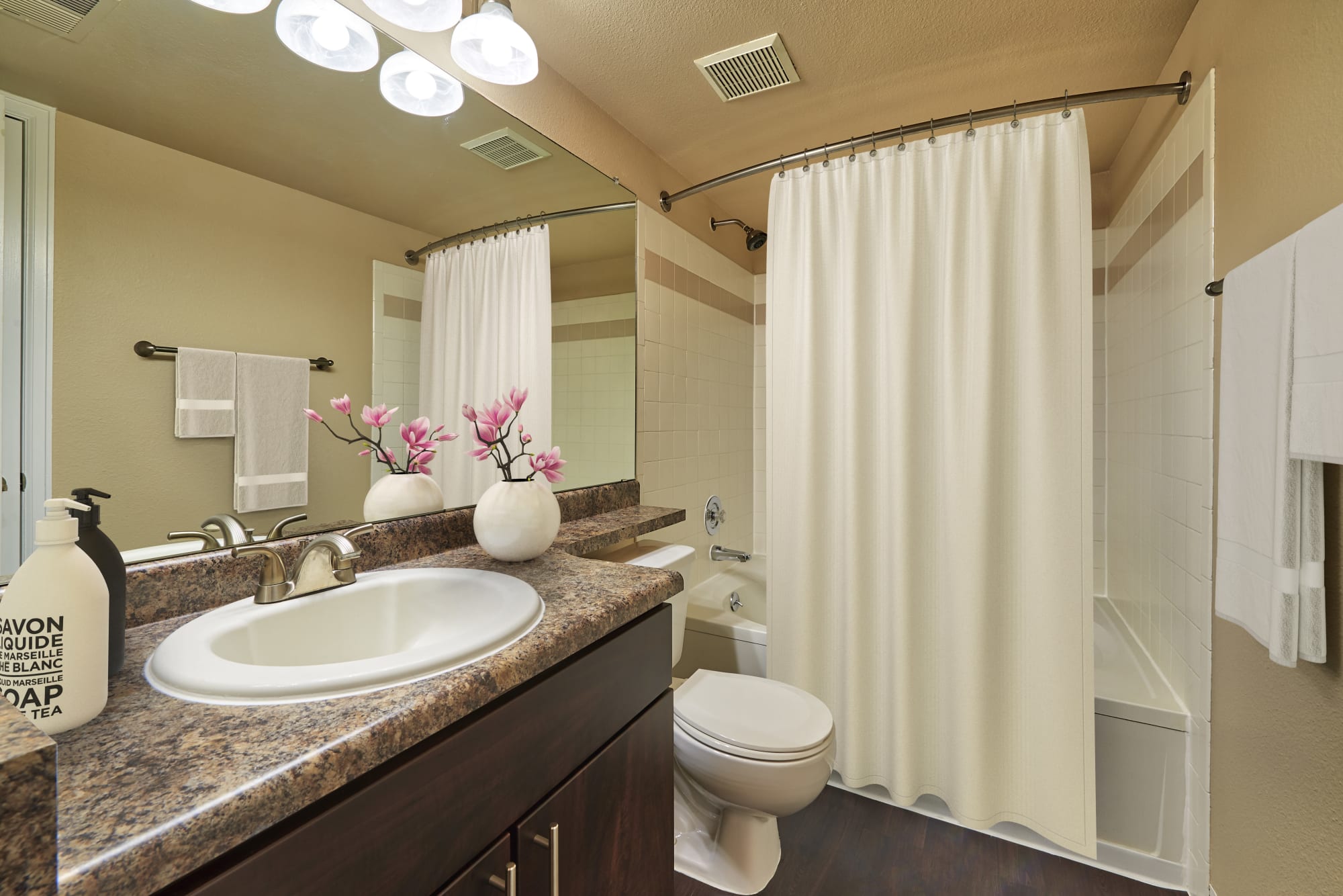 Bathroom with a large vanity mirror at Villas at Homestead Apartments in Englewood, Colorado