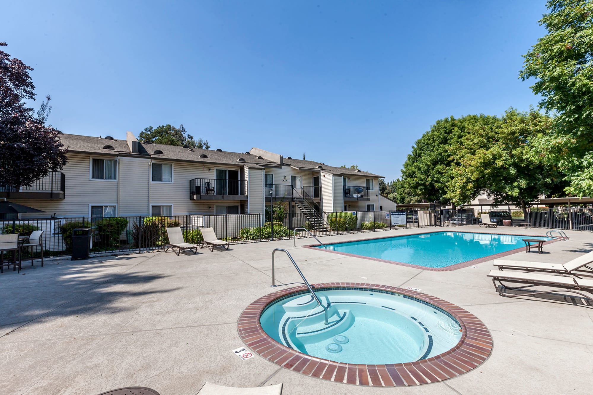 The outdoor hot tub and swimming pool at The Woodlands Apartments in Sacramento, California