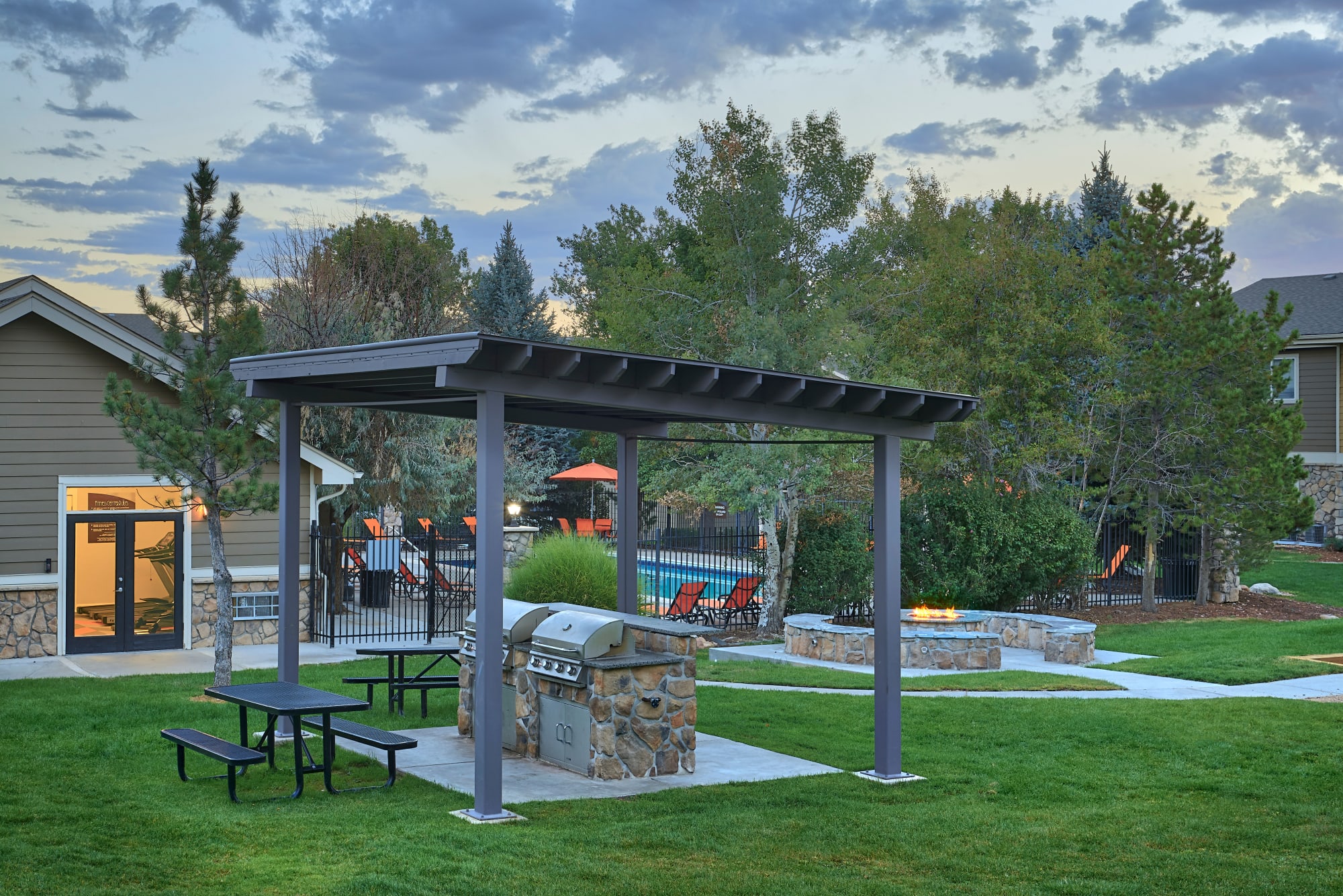 The fire pit lounge and covered bbq area at Crossroads at City Center Apartments in Aurora, Colorado