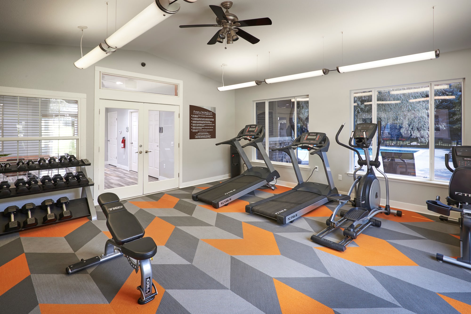 Fitness center with free weights and cardio machines at Crossroads at City Center Apartments in Aurora, Colorado