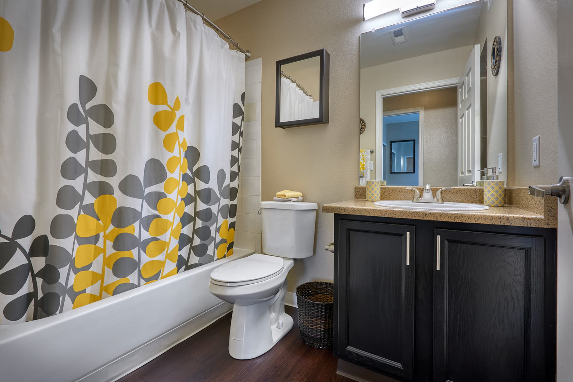 Bathroom with pedestal sink and tub at Crossroads at City Center Apartments in Aurora, Colorado