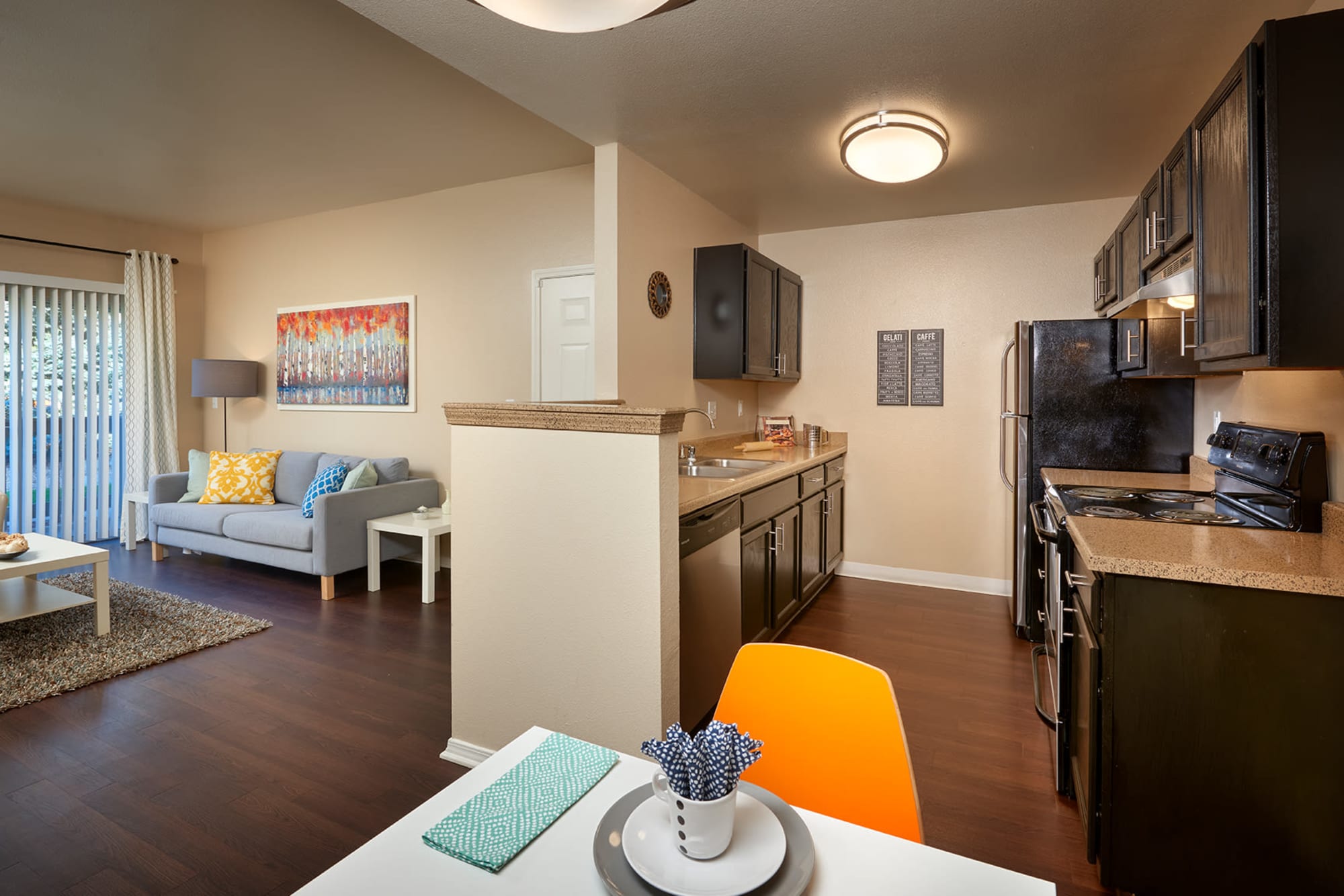 Kitchen and living room at Crossroads at City Center Apartments in Aurora, Colorado