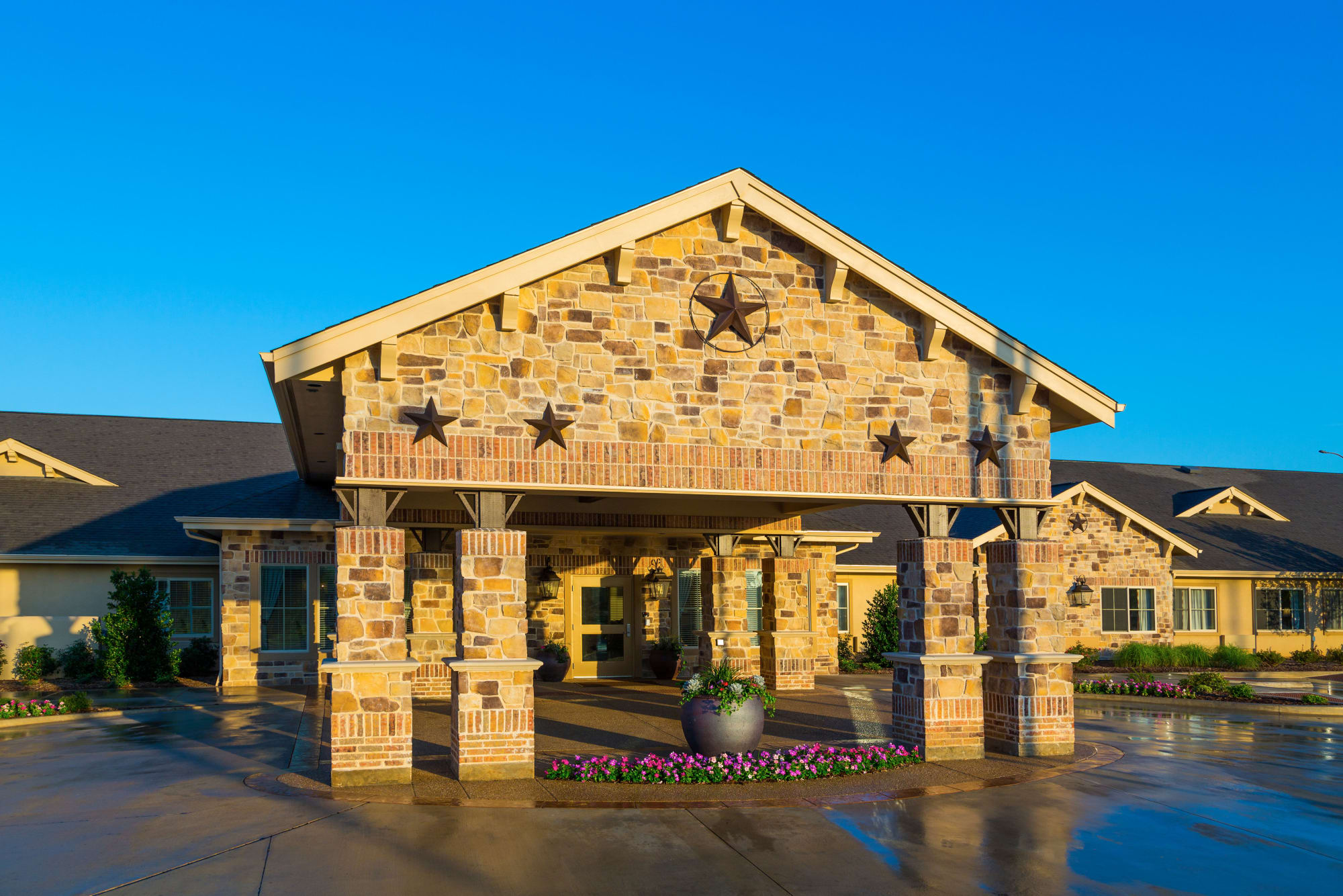 Sunny main entrance with star decorations at Saddlebrook Oxford Memory Care in Frisco, Texas