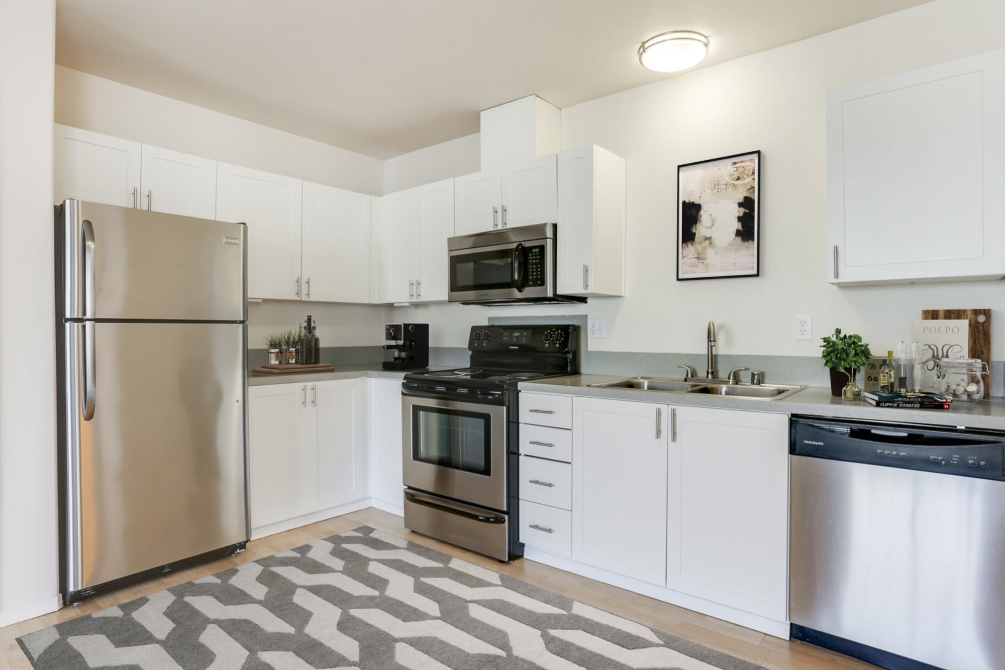 White kitchen with stainless steel appliances at The Addison Apartments in Vancouver, Washington