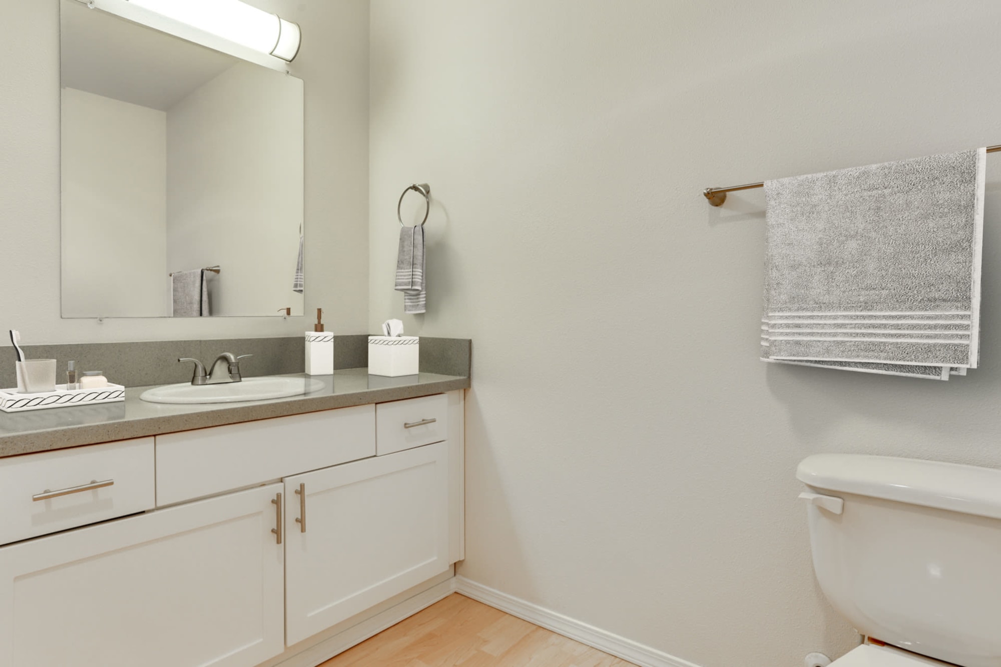 Renovated bathroom with white cabinets and a bathtub at The Addison Apartments in Vancouver, Washington