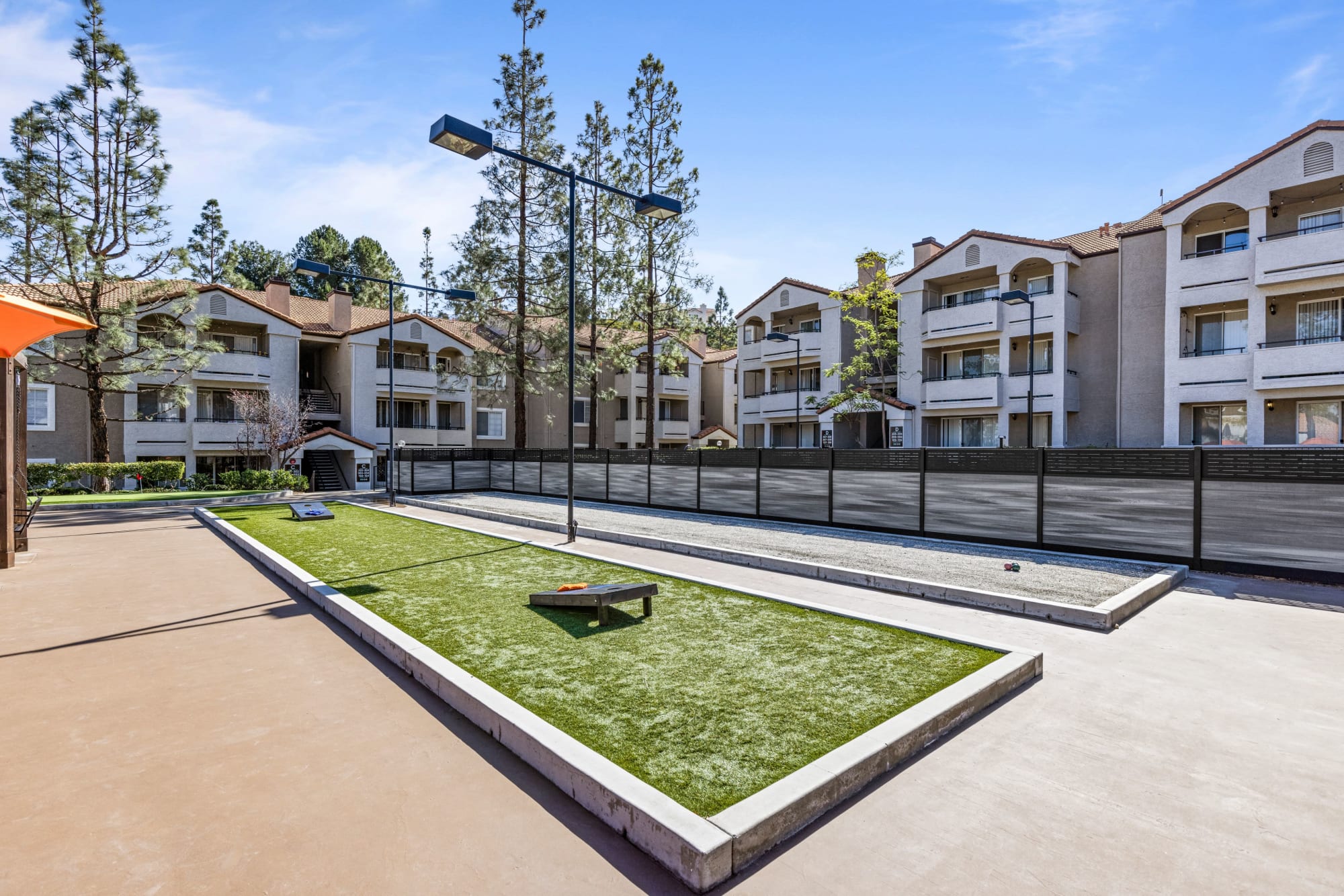 Courtyard with corn hole at Sierra Del Oro Apartments in Corona, California