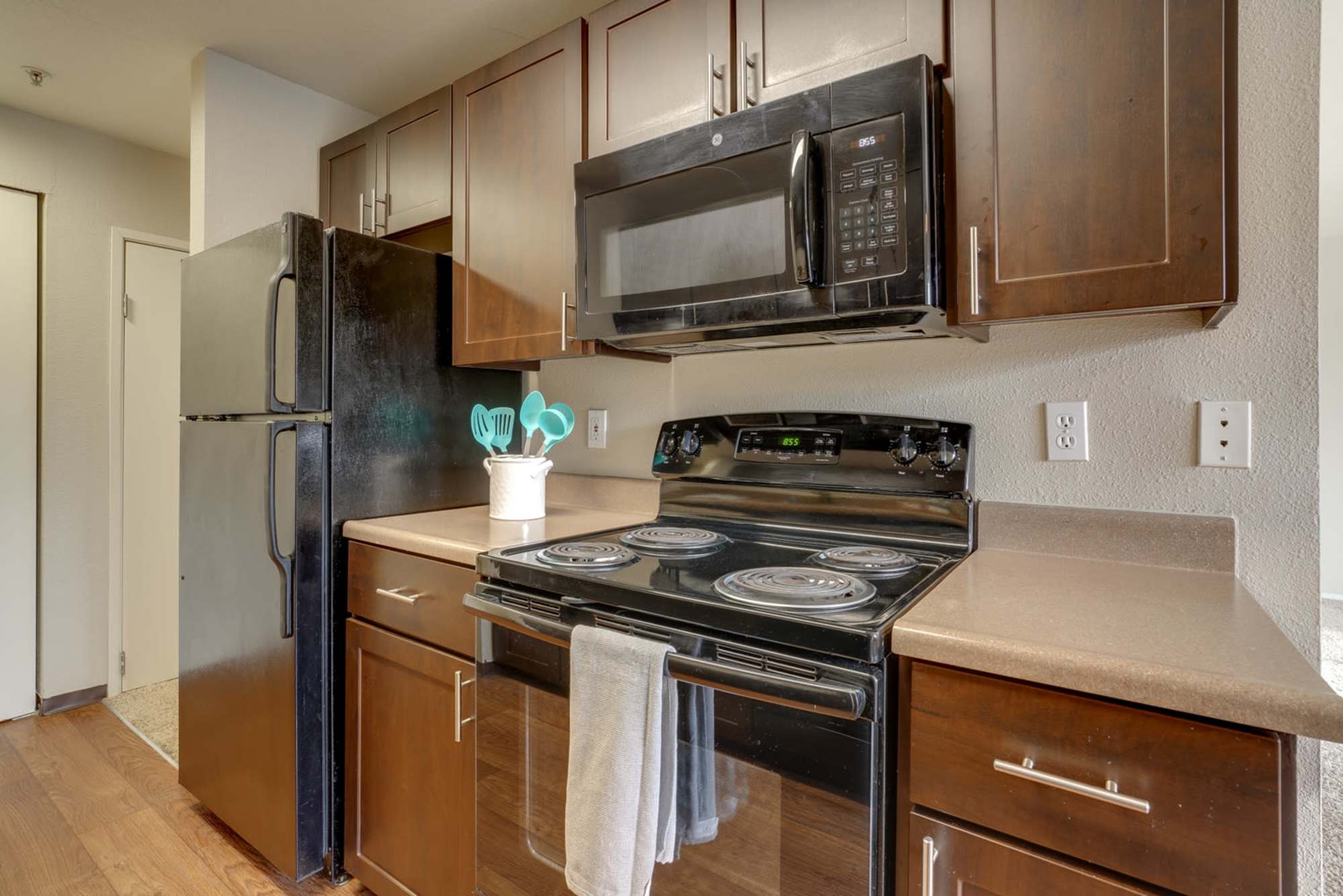 Brown cabinets in a renovated kitchen with stainless steel appliances at Renaissance at 29th Apartments in Vancouver, Washington