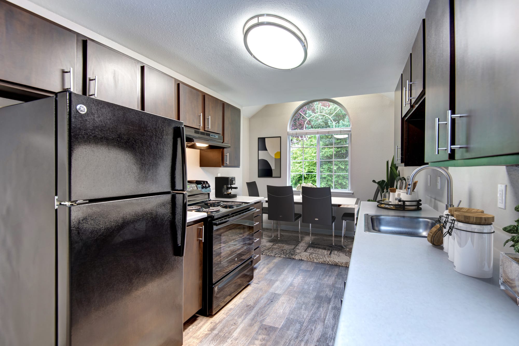A spacious kitchen with hardwood-style flooring at Wellington Apartment Homes in Silverdale, Washington
